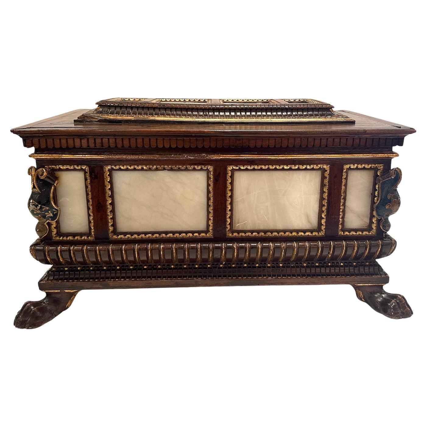  Une belle boîte à charnière en noyer, sculptée à la main, avec des inserts en marbre et des détails peints et dorés à la main.
