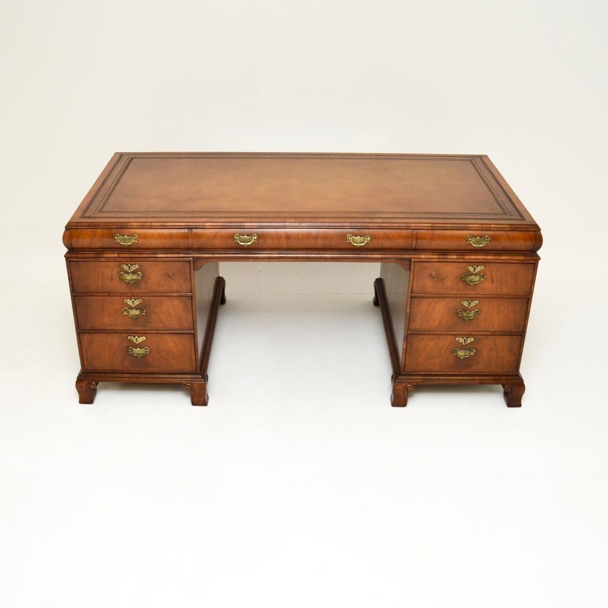 A magnificent and large antique walnut leather top partners desk. This was made in England, it dates from around the 1900-1920 period.

It is of superb quality with a gorgeous design, the slightly rounded top edge means this type of desk is