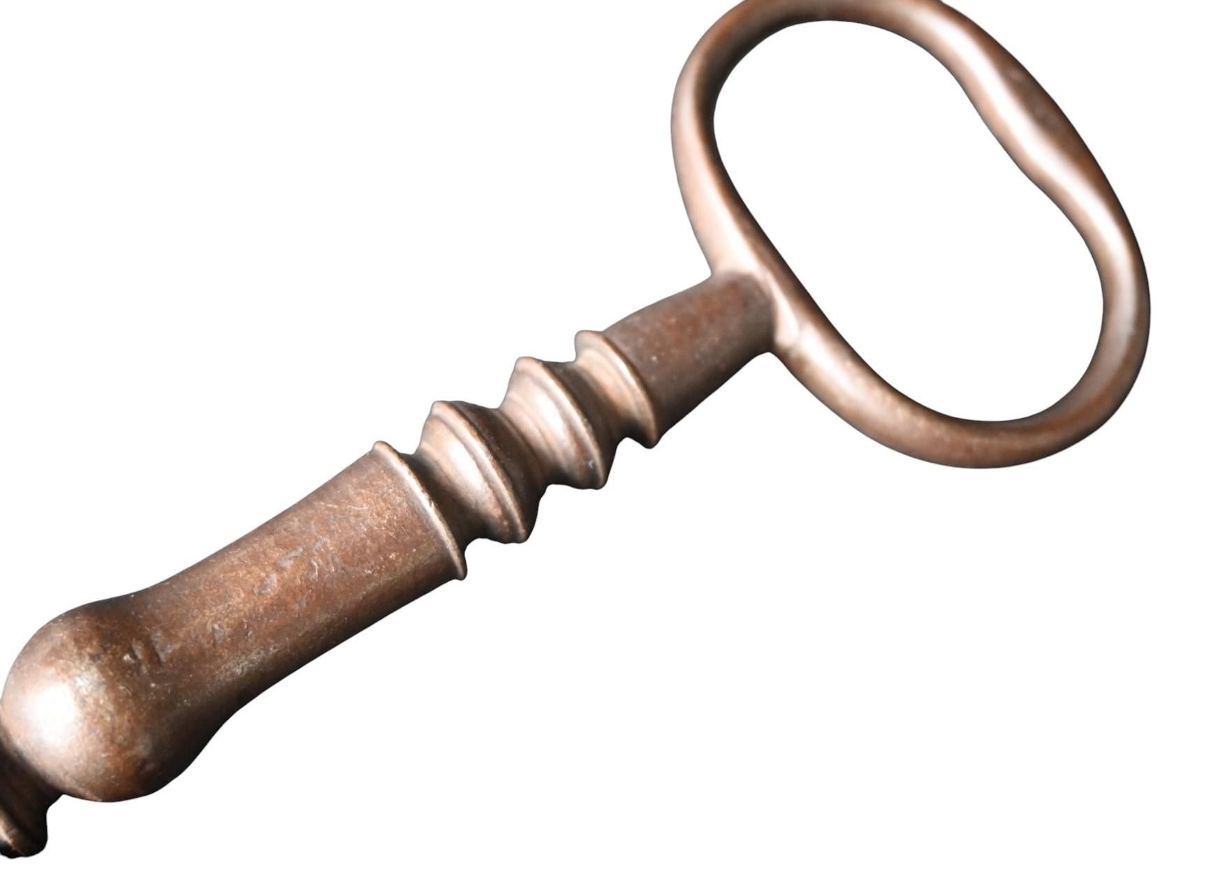 An impressive and authentic antique iron key dating to the late 17th century. Measuring 18.5 cm in length, this key was likely made for a large estate, church, or strongroom lock. The bit is finely crafted with a complex ward pattern, measuring 3.5
