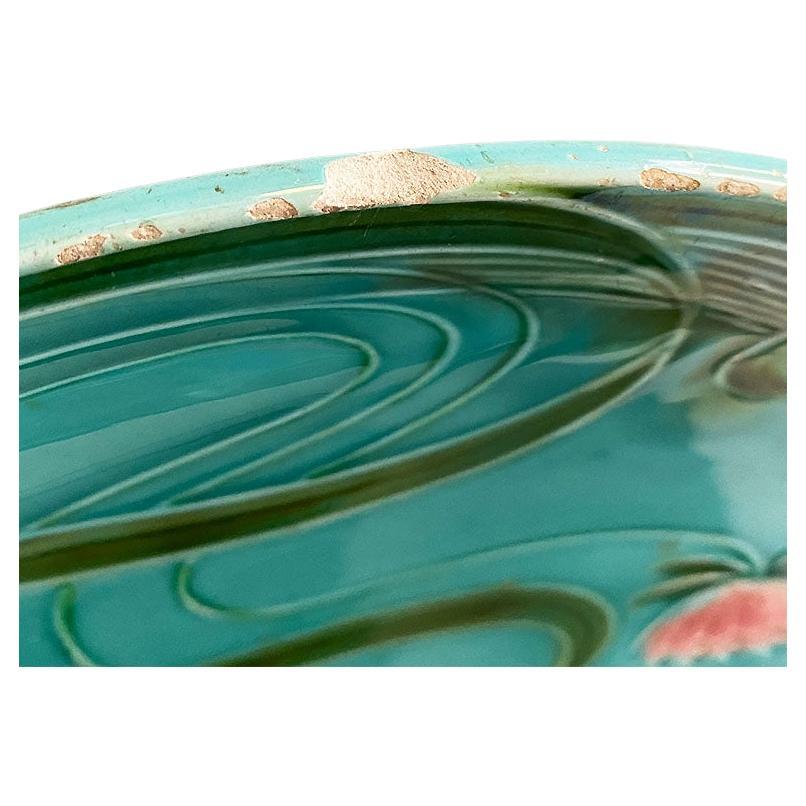 Early Art Deco or Art Nouveau ceramic polychrome majolica serving platter by Villeroy & Boch. This beautiful piece is created from ceramic and glazed in vibrant greens, blues, and pinks. The edge of the plate is pierced and decorated with large