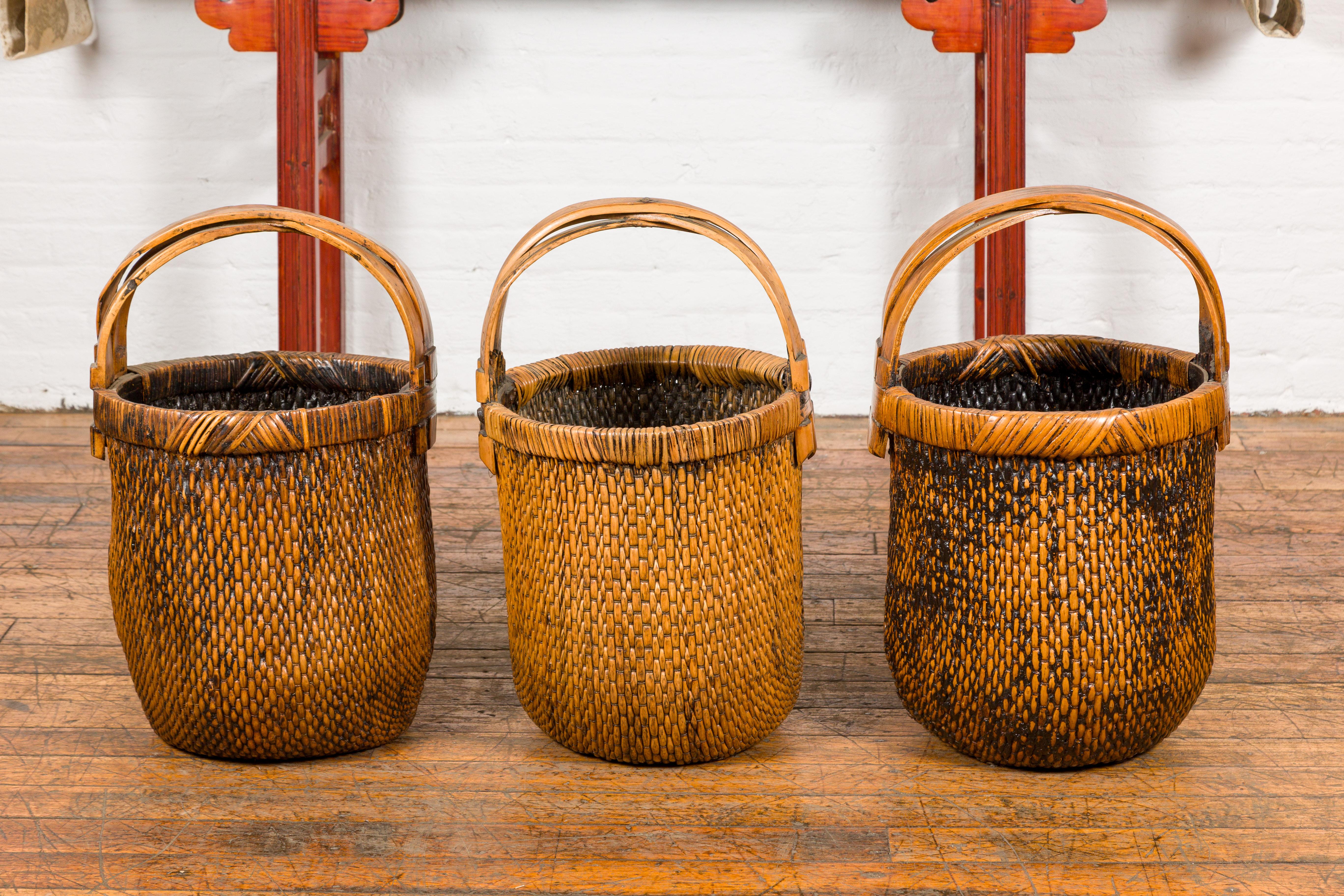 Three large and antique willow grain baskets with wooden handles, priced and sold each. Elevate your home with a touch of rustic elegance through these exceptional large and antique willow grain baskets, each featuring wooden handles and