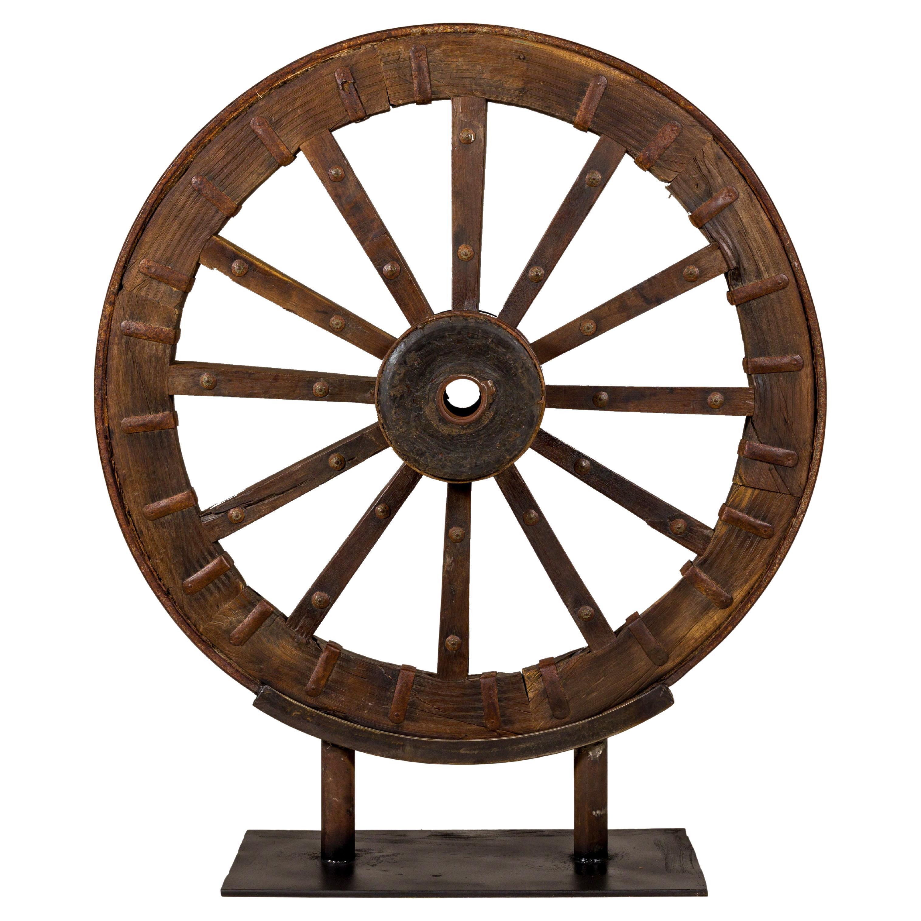 Großes antikes Karrenrad aus Holz und Metall, montiert auf maßgefertigtem Sockel