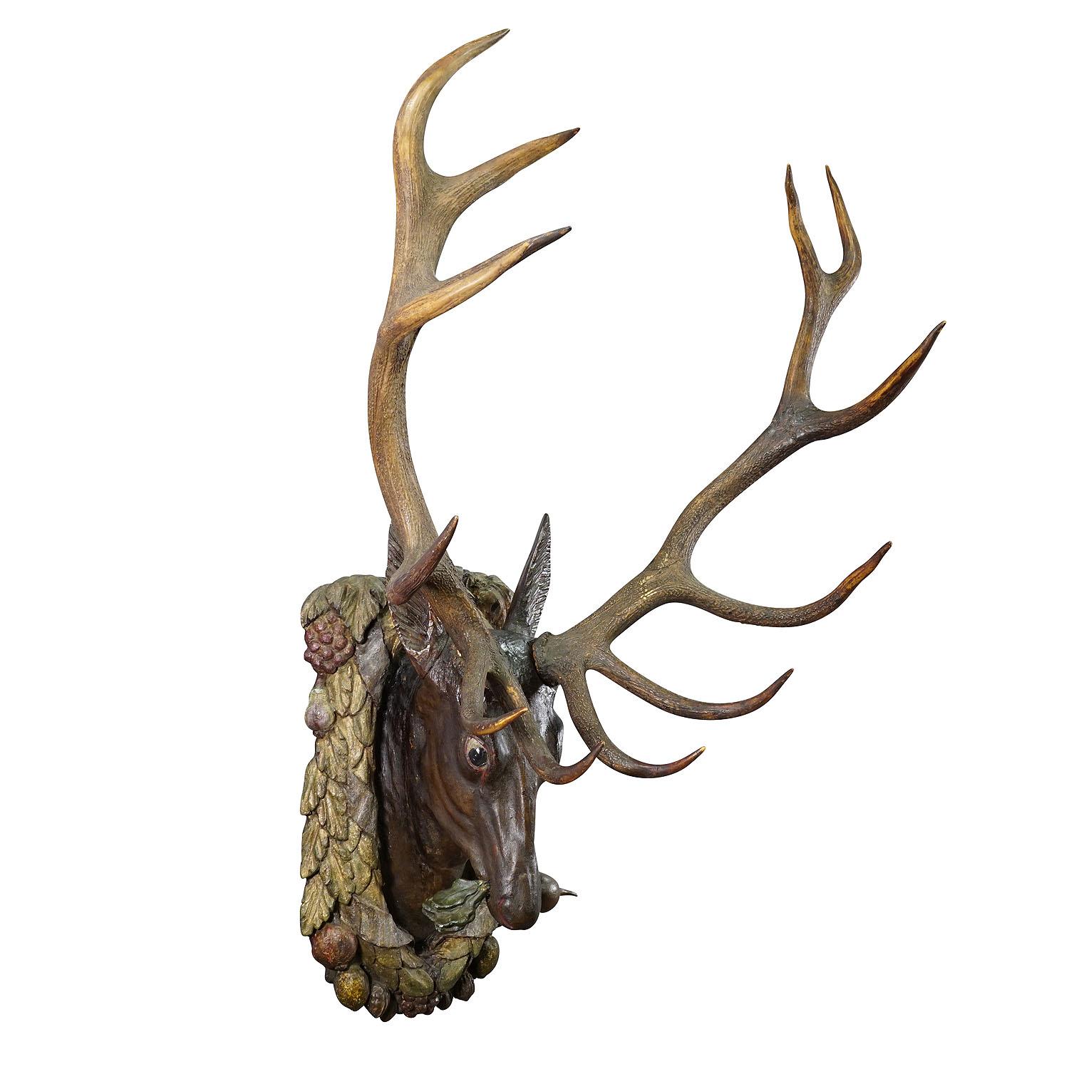 Large Antique Wooden Carved Black Forest Baroque Stag Head

A large antique Black Forest baroque deer head. Carved in typical abstract style of the early 18th century. It is mounted on a garland-like wooden carved plaque depicting fruits and