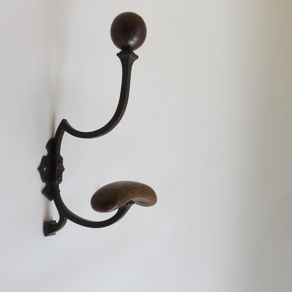 A large impressive wall mounted coat hook.  Very good quality and well made, wrought iron with Oak details, originally used for hanging coats and hats. Some distressing over all, wonderful shaped hook for hat and coats.

A very unusual fabulous
