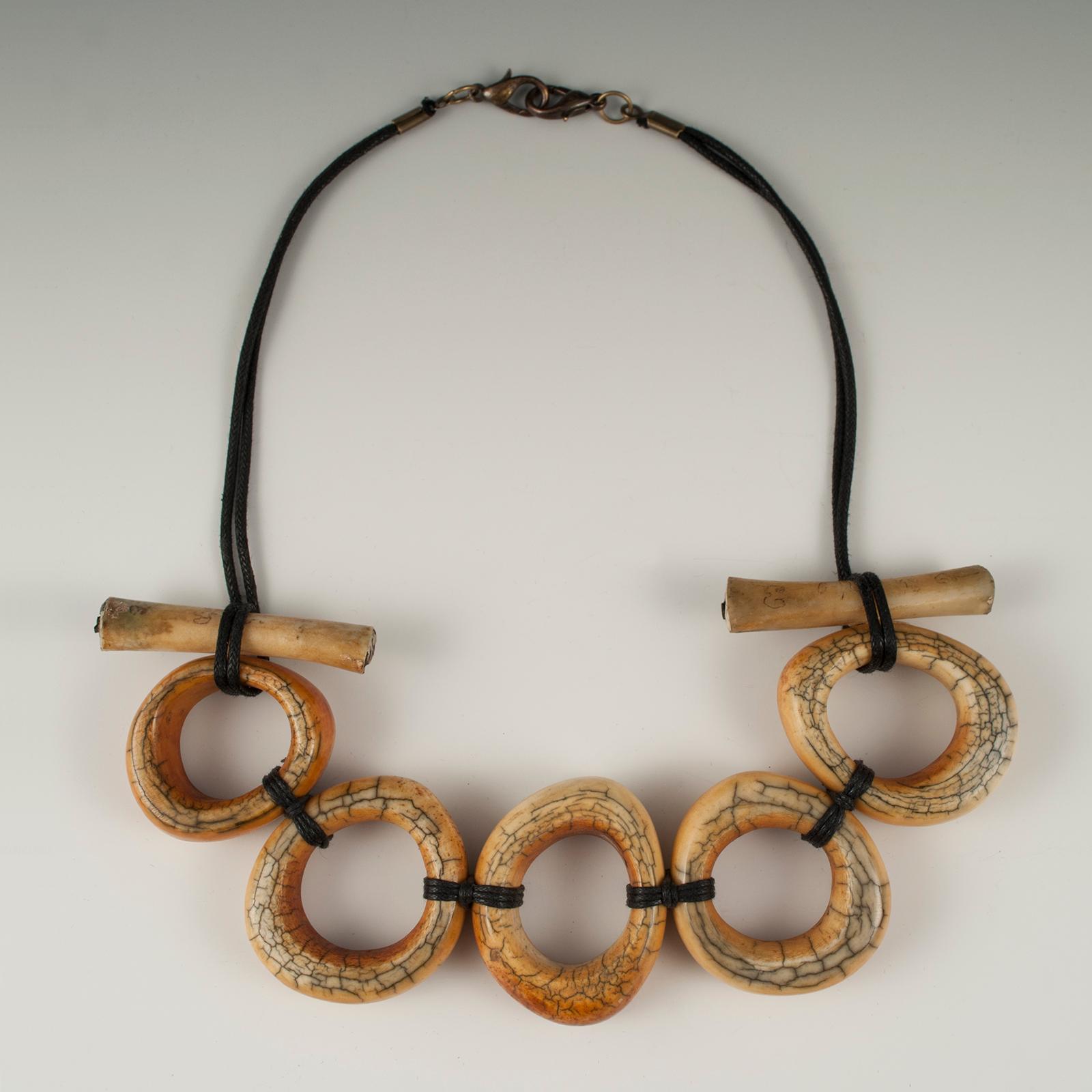 Offered by Zena Kruzick
Large antique yak bone tribal necklace by Claire Ginioux, Paris, France

Old yak bone rings, which were worn in their hair by young Tibetan men, are combined with inscribed chicken bones used for divination in Thailand to