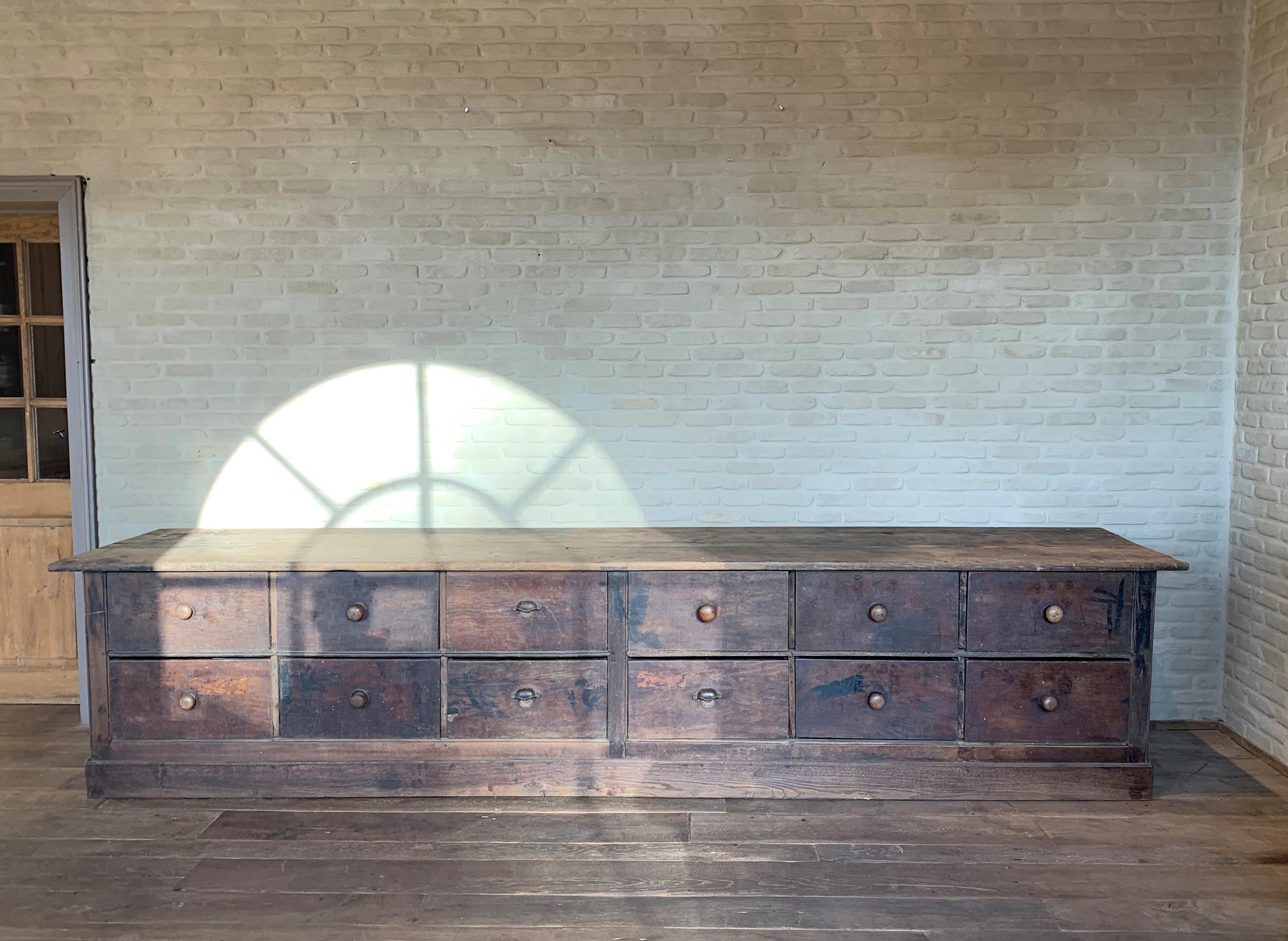 This massive chest of drawers probably started life as a custom shop or apothecary counter. The back and sides are panneled and retain the faded original paint. These pieces are rare to find and certainly with all drawers original. The top has