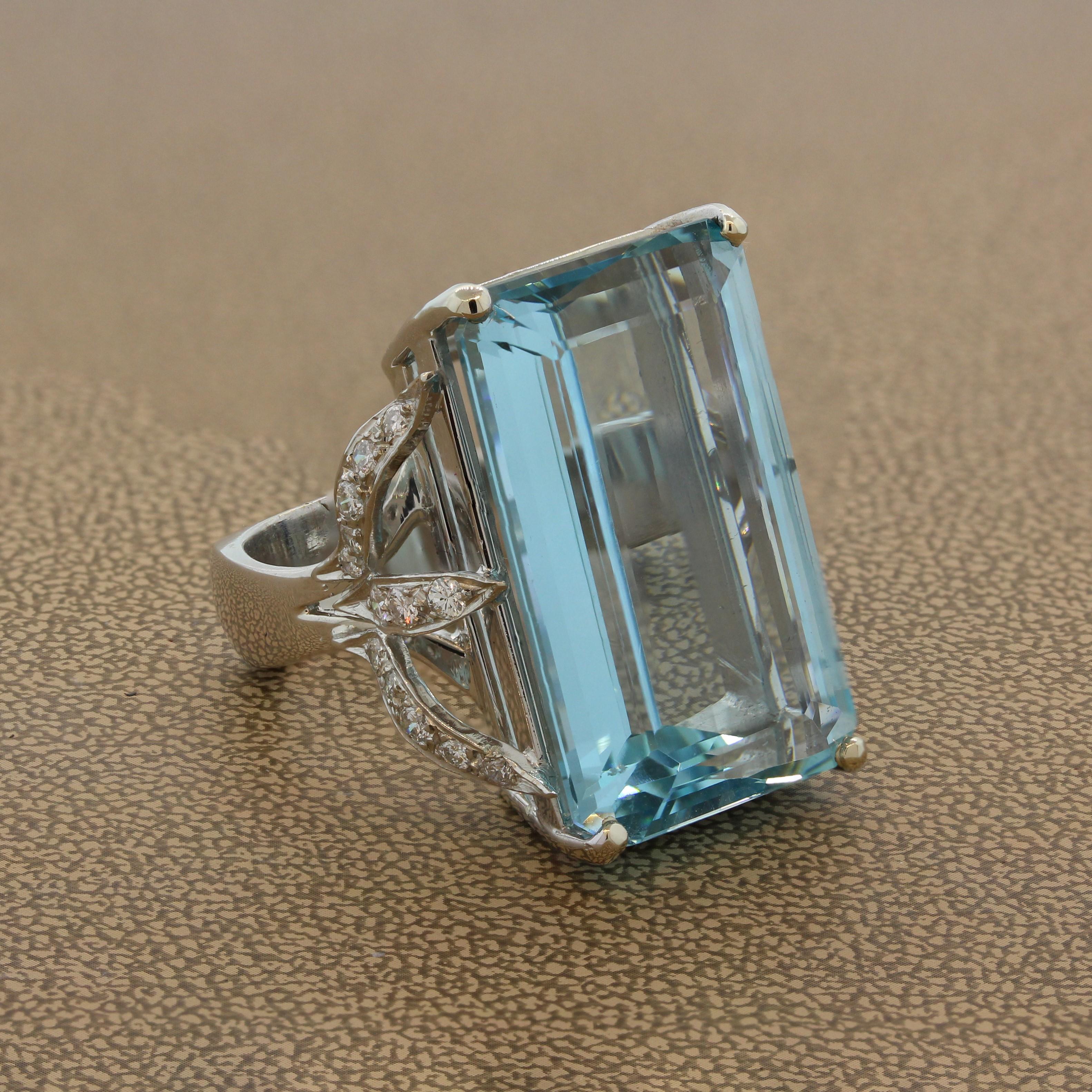 An ostentatious cocktail ring featuring a 38.56 carat aquamarine with the desired ocean blue color. The emerald cut aquamarine is set in a 14K white gold setting with a leaf design on two sides of this exuberant ring that is studded with 1.00 carat