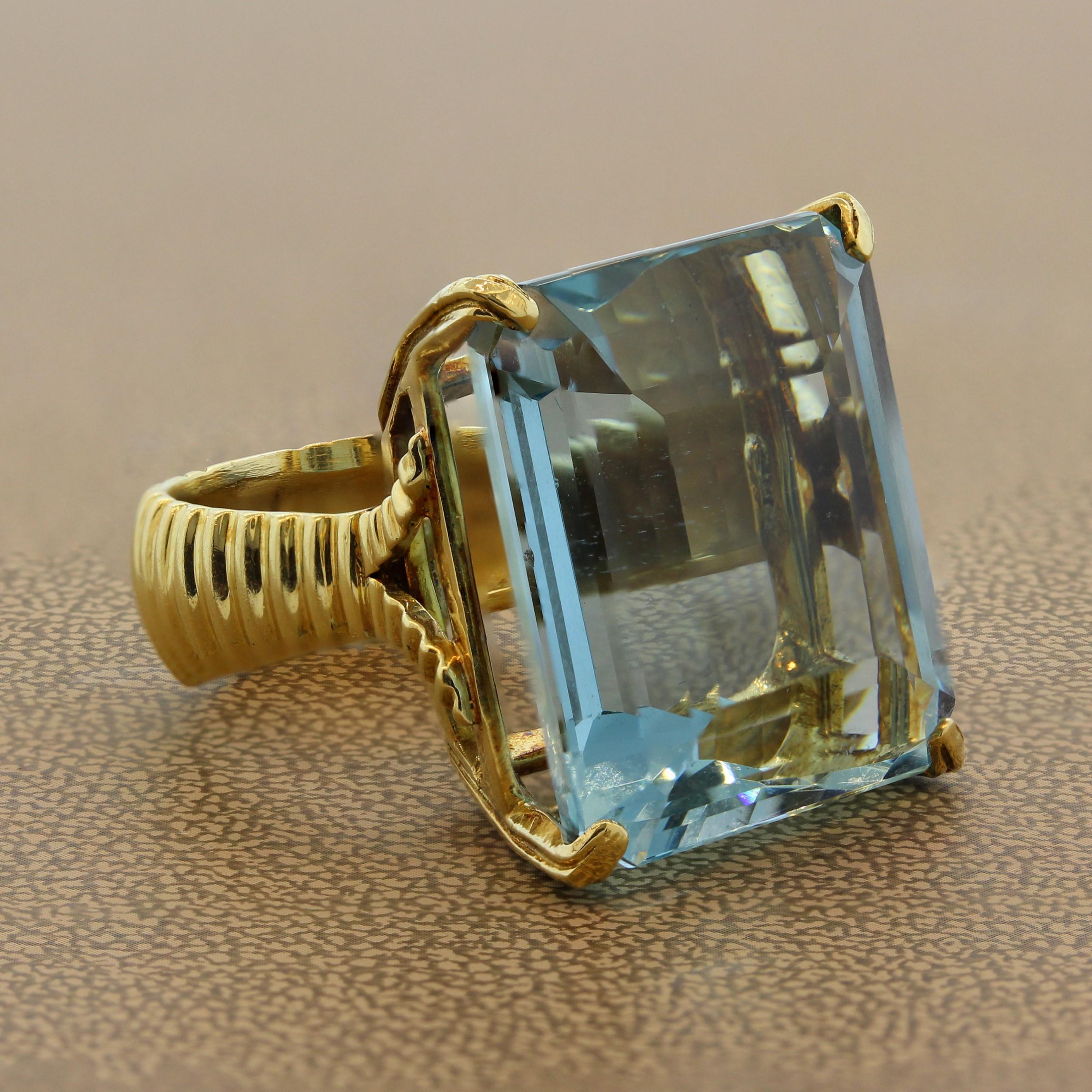 An exceptional gem set ring featuring a 45 carat aquamarine with exception depth of color. This solitaire emerald cut aquamarine has the ideal sea blue hue that is most desired in the trade. It is set in 18K yellow gold mounting with a textured