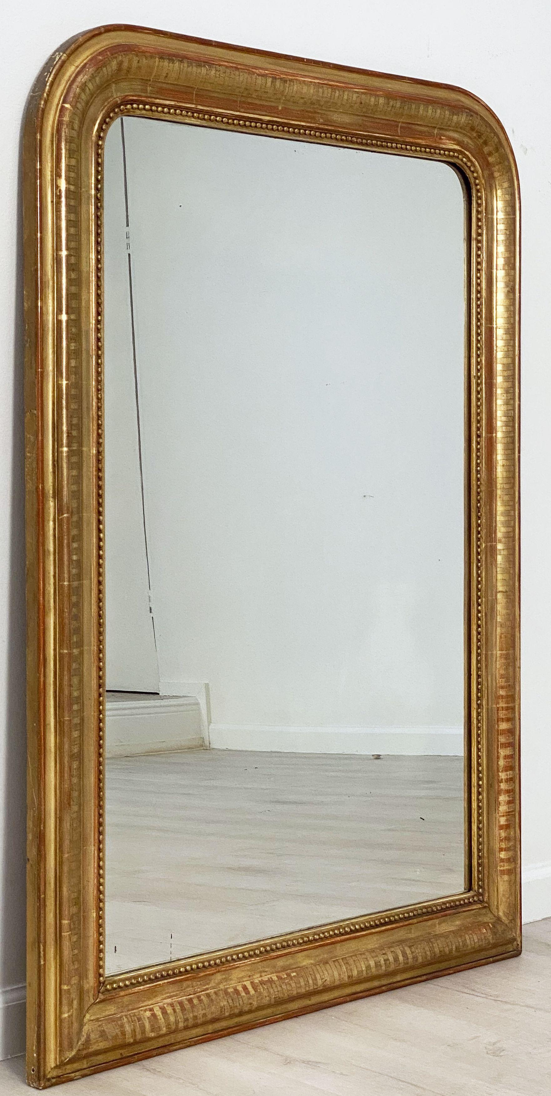 A handsome large Louis Philippe gilt wall mirror featuring a lovely moulded surround and an etched design showing through gold-leaf.

Dimensions: H 50 5/8 inches x W 37 1/4 inches

Other sizes available in this style.