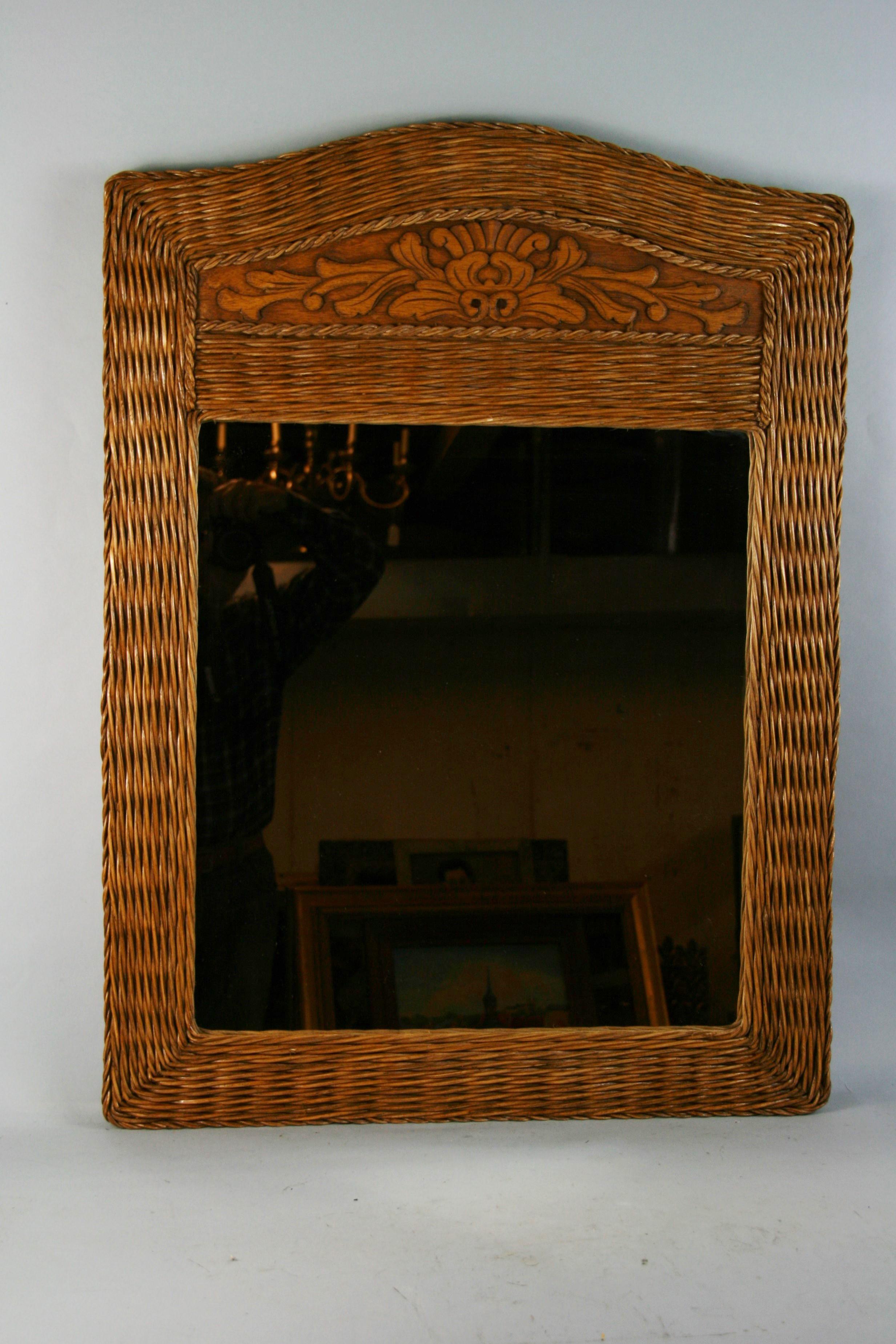 Grand miroir en rotin avec insert en bois sculpté.