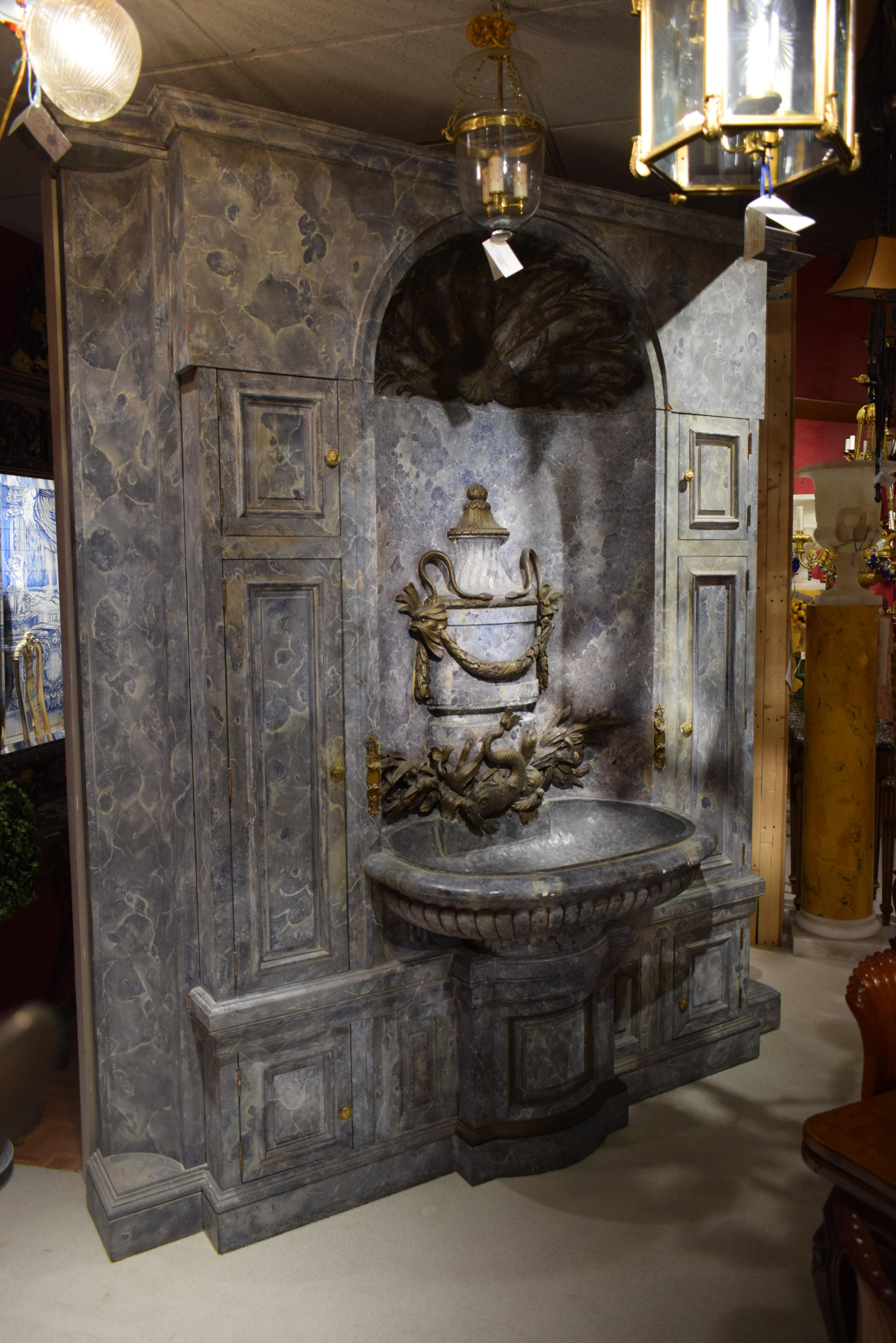 Extraordinary Lavabo depicting urn ornated with garlands & dolphins. Having a pewter basin and the cabinet complete with faux marble grey. The two sides added later.