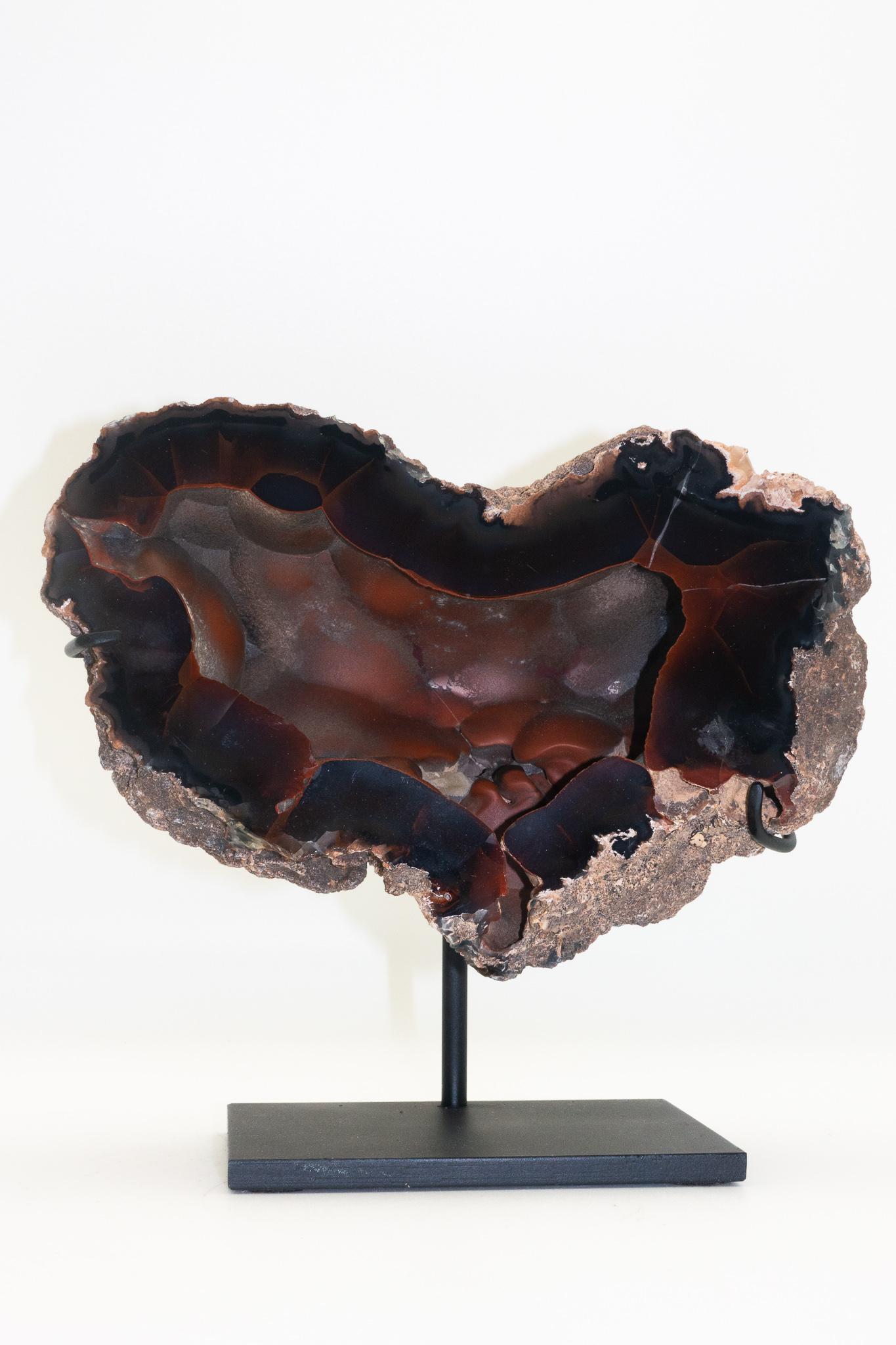 Large Argentinian Red Fox Agate specimen mounted on a black steel base. The smoky red-black Red Fox Agate is also known as Crater Agate, as these unique specimens are harvested close to an ancient crater near the town of Chubut, Patagonia, Argentina.