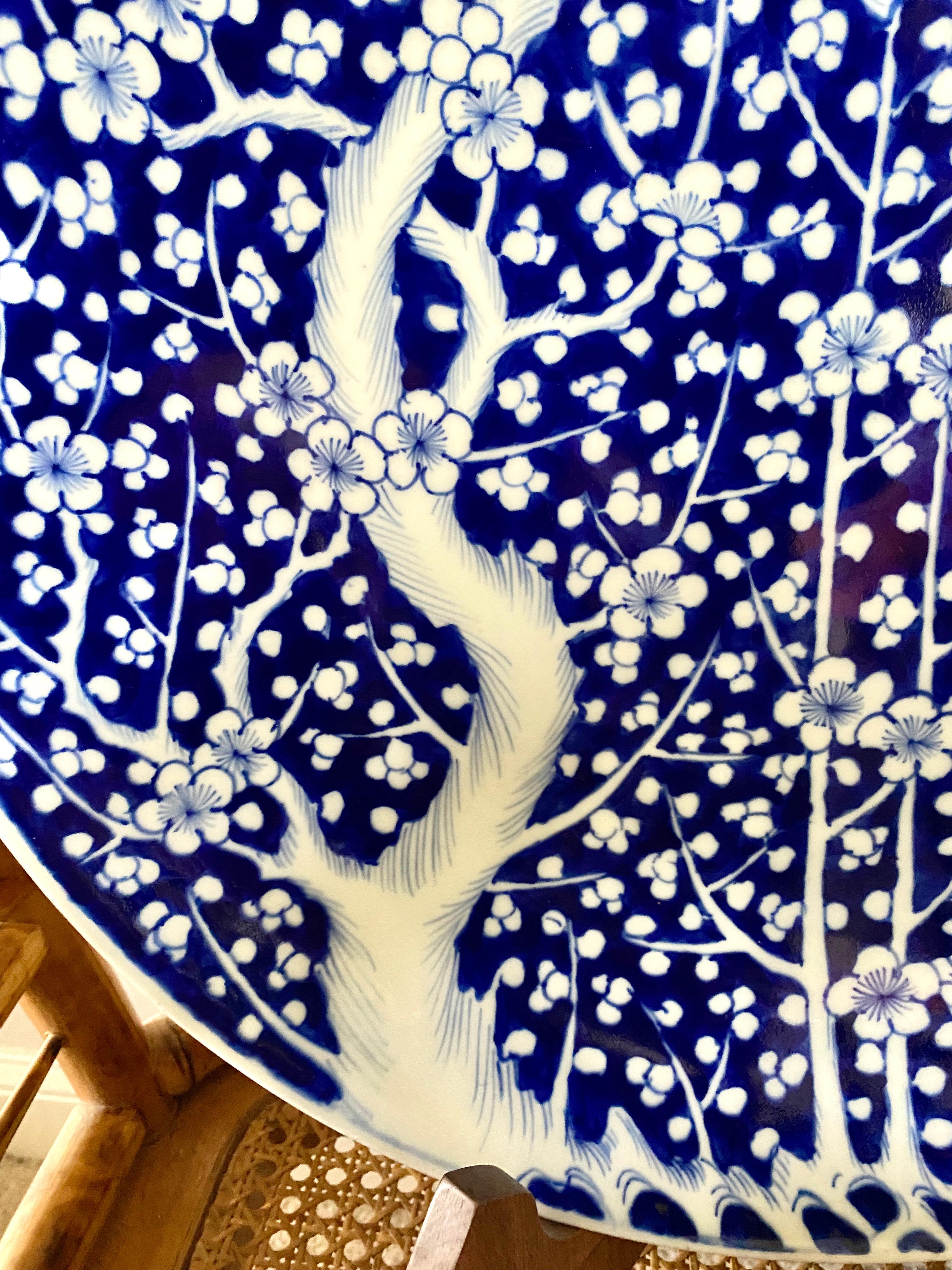 Il s'agit d'un très grand chargeur bleu et blanc d'Arita, peint à la main dans un motif de prunus. Le chargeur date du début ou du milieu du XXe siècle et est dans l'ensemble en très bon, voire en excellent état. La lèvre inférieure présente une
