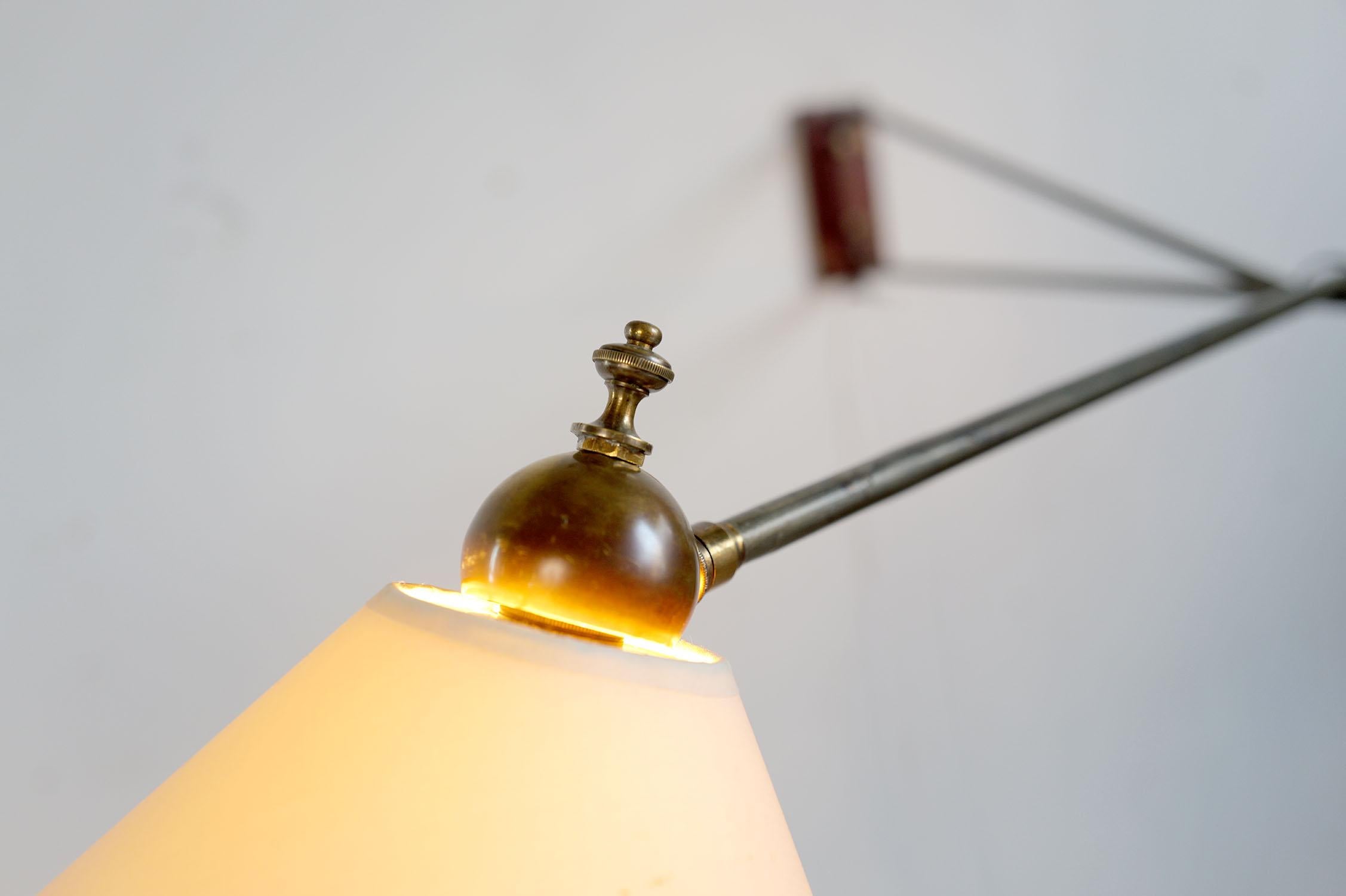 Grande lampada da parete a doppio braccio, Francia 1950. Il supporto in legno è arricchito da bulloni in ottone, i due bracci laccati in grigio ruotano e sostengono un doppio riflettore montato su un giunto a sfera. Grazie alla sua larghezza (182
