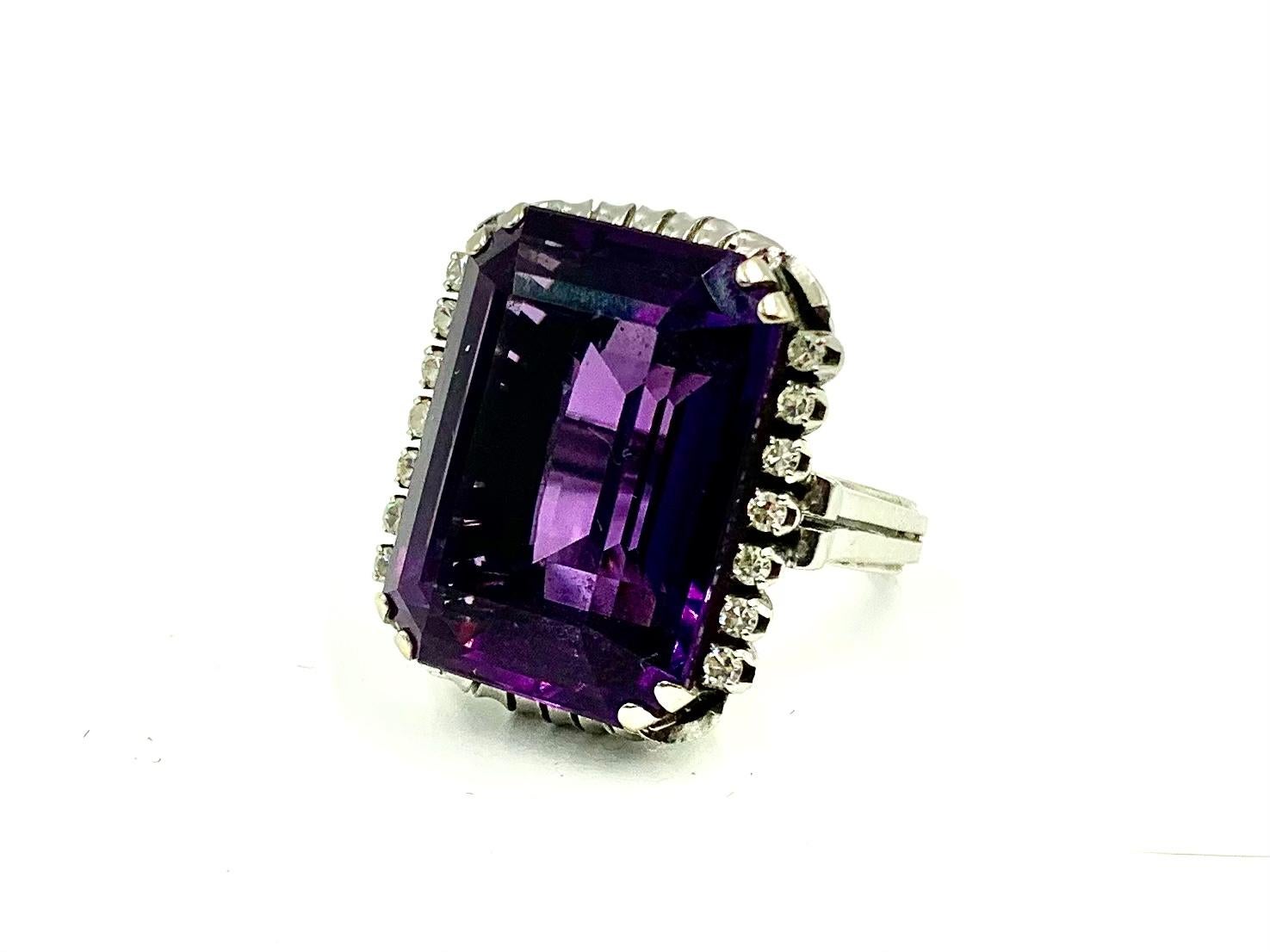 Fine, large Art Deco period Amethyst and Diamond ring in a beautifully detailed 18K white gold setting.
Early 20th Century
The amethyst, measuring approximately 22.5 carats, lively rich purple color.
14 single cut diamonds, seven on each side of the