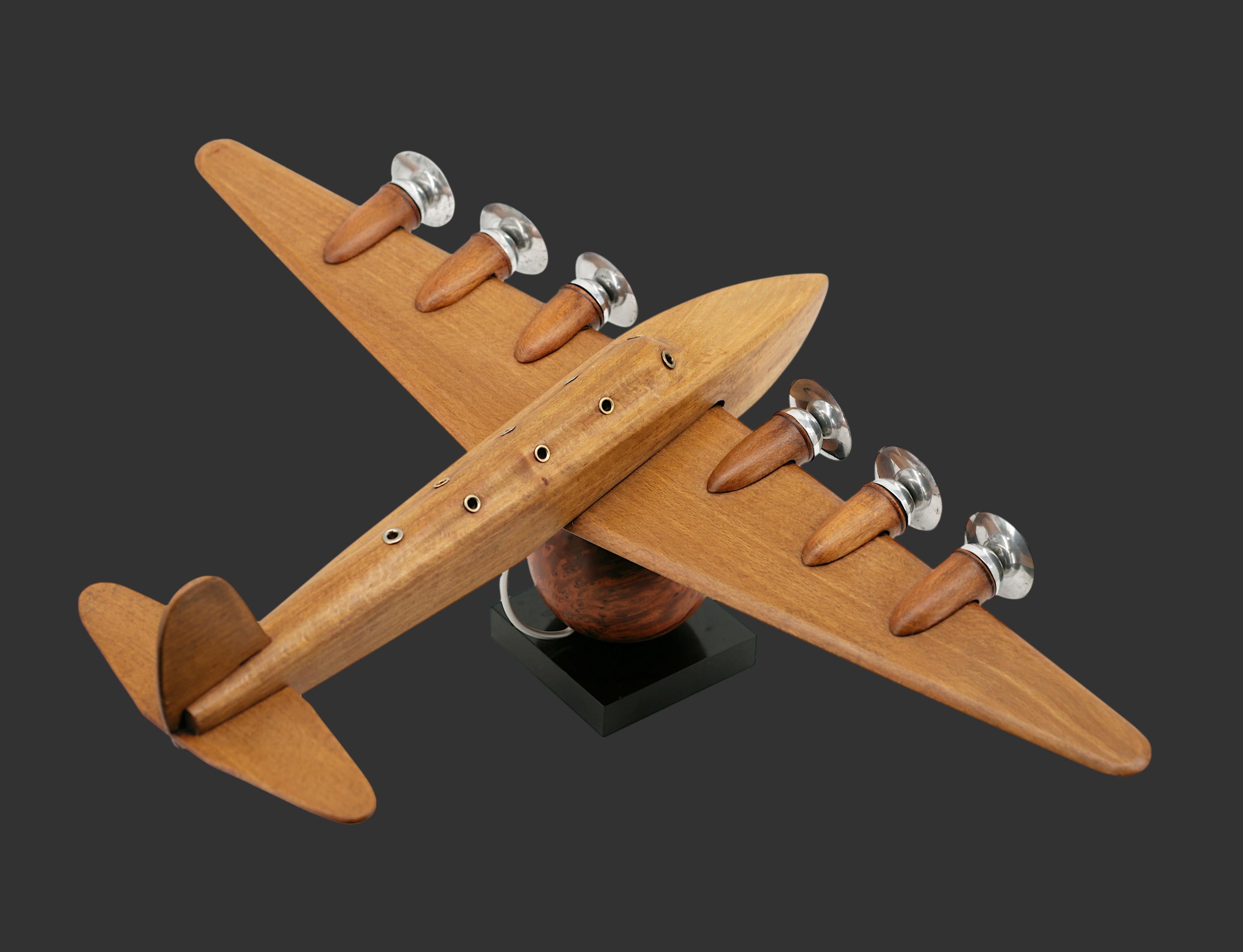 Grand avion français Art Déco par Anthoine ART BOIS, France, années 1930. Bois, thuya, métal et marbre. Avion en bois. Boule de thuya (terre). Base en marbre noir. Largeur : 25.8