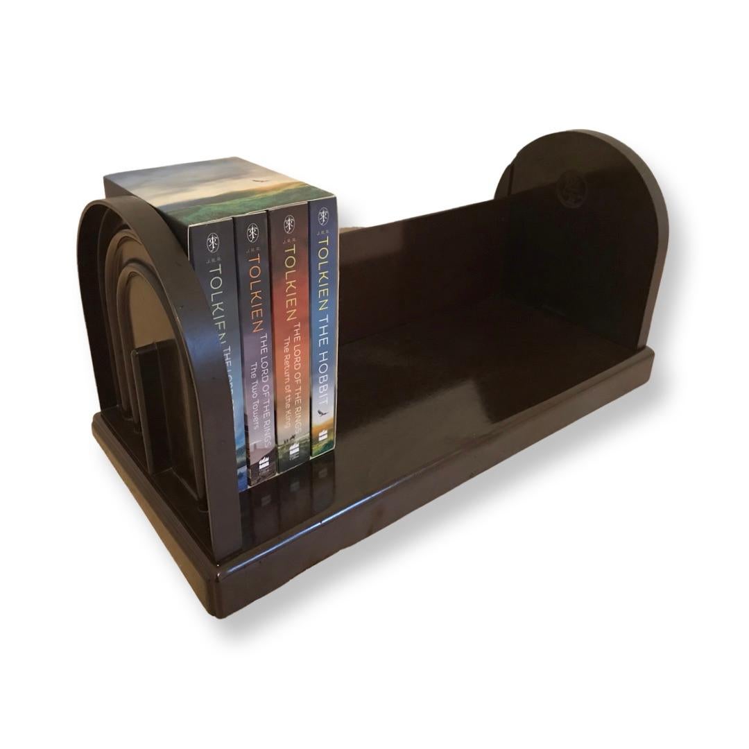 A fabulous 1930s Bakelite book trough by EBCO bookcase company, Made entirely of Bakelite, this wonderful piece has survived completely intact, with no chips or cracks or repairs. The colour is of mottled chocolate. It features 2 elliptical ends