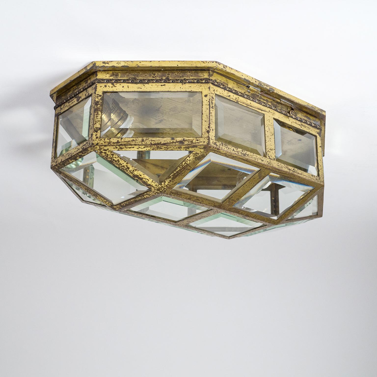 Rare large Adolf Loos style flush mount from the early 20th century in brass with faceted glass elements. The elongated octagonal structure is made entirely of brass, down to the original E27 sockets (with new wiring). This piece is extremely well