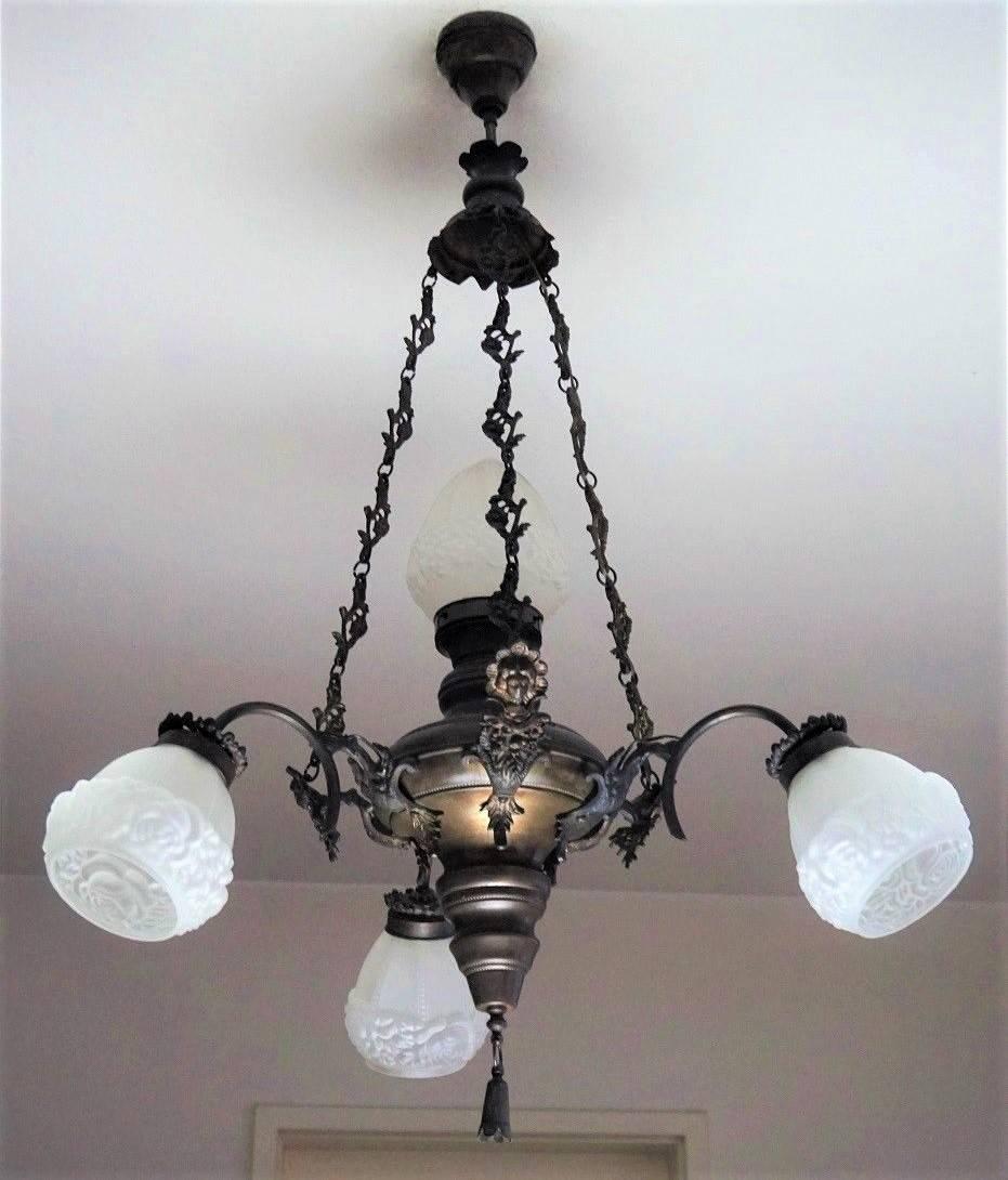 Large Art Deco brass four-light chandelier with frosted glass in high relief globes.
Measures:
Height 39.50 in (100 cm)
Diameter 24.50 in (62 cm).
     