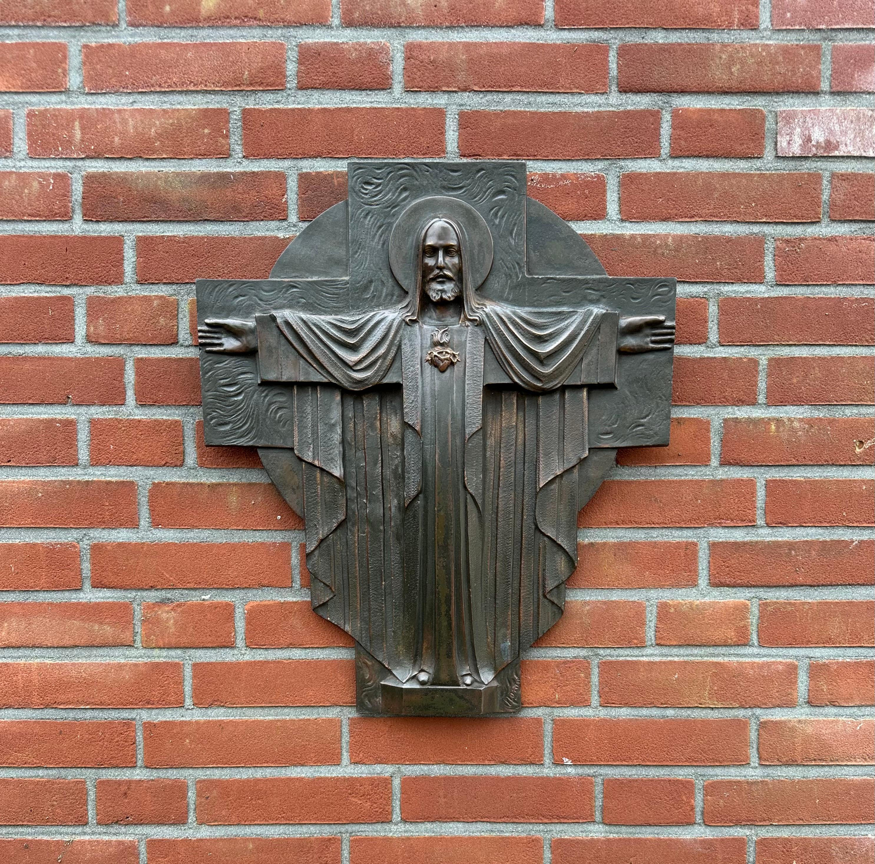 Rare and beautiful bronze Art Deco Christ wall sculpture.

Some works of religious art depict Christ in terrible agony, but this symmetrical specimen from the European Art Deco era is ofcourse a Holy Heart in a cross-like manner and here Jezus