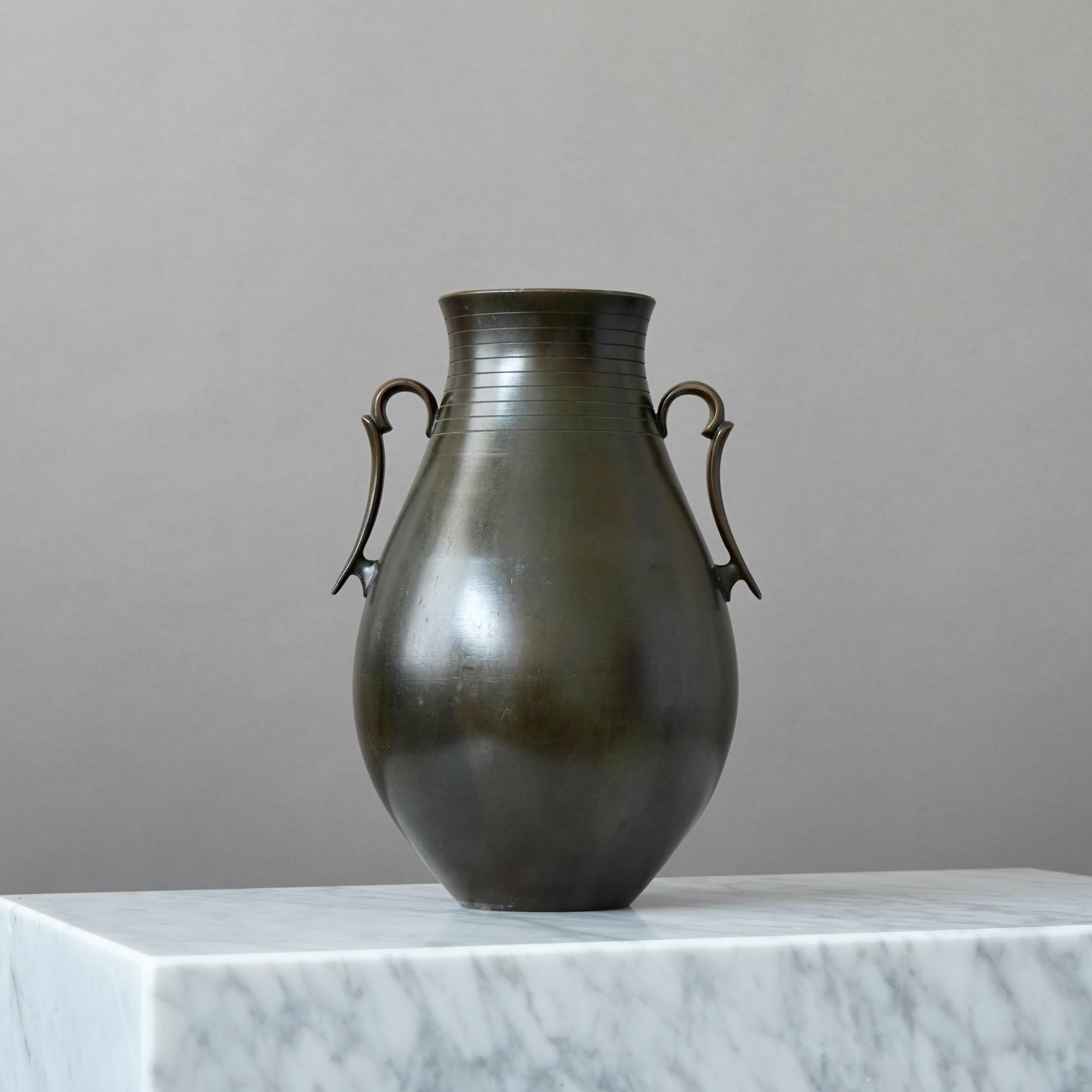 Un grande e bellissimo vaso in bronzo con un'incredibile patina. 
Realizzata da GAB Guldsmedsaktiebolaget, Svezia, anni '30.  

Condizioni discrete. Presenta una grossa ammaccatura sulla parte inferiore di un lato del vaso (nella foto).
Timbro