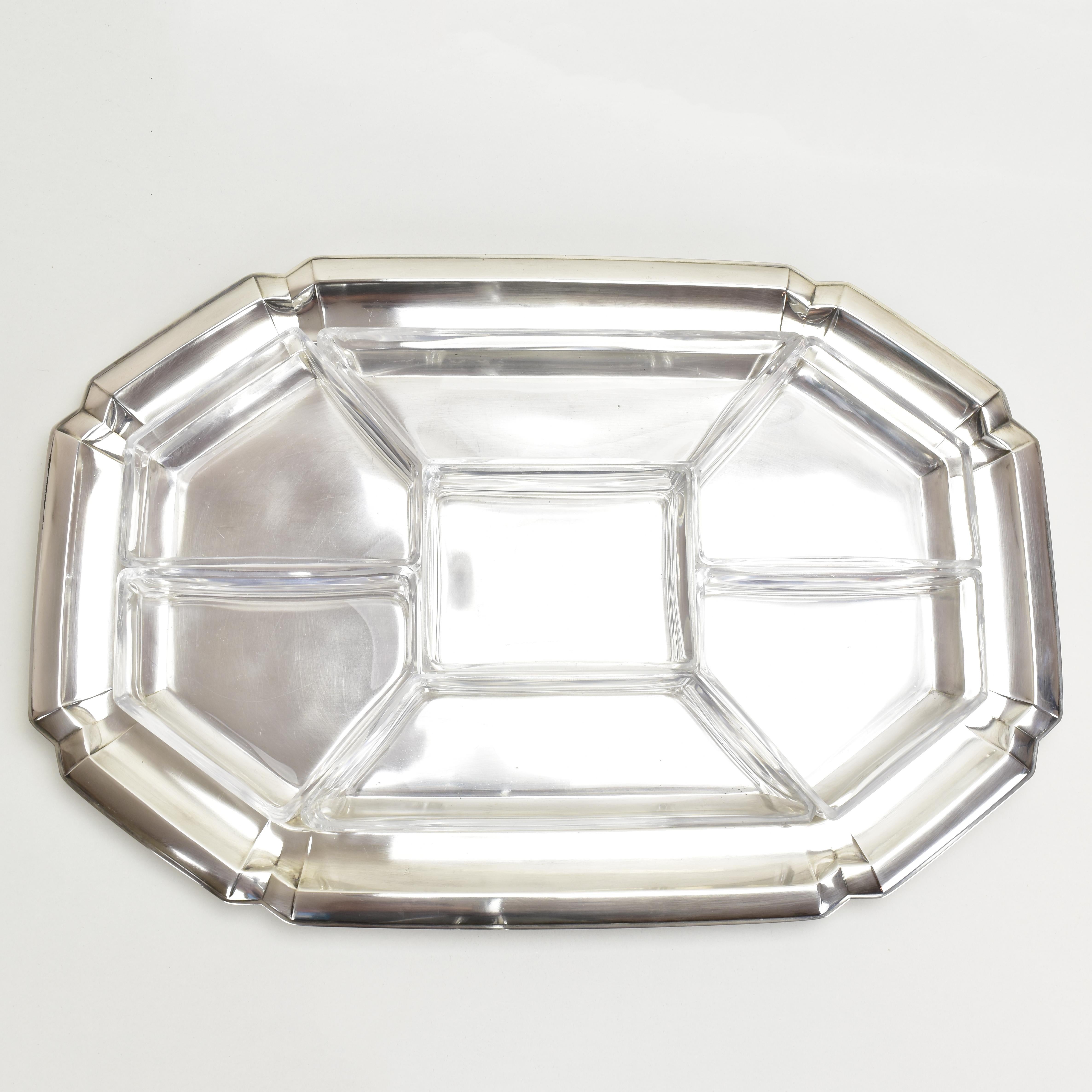 Dieses atemberaubende Art-Déco-Snack-Tablett ist eine schöne Ergänzung für jede Cocktailparty. Das Tablett ist aus versilbertem Messing gefertigt und trägt sieben originale Schalen aus geschliffenem Kristall.
Das Set ist in sehr gutem Zustand ohne