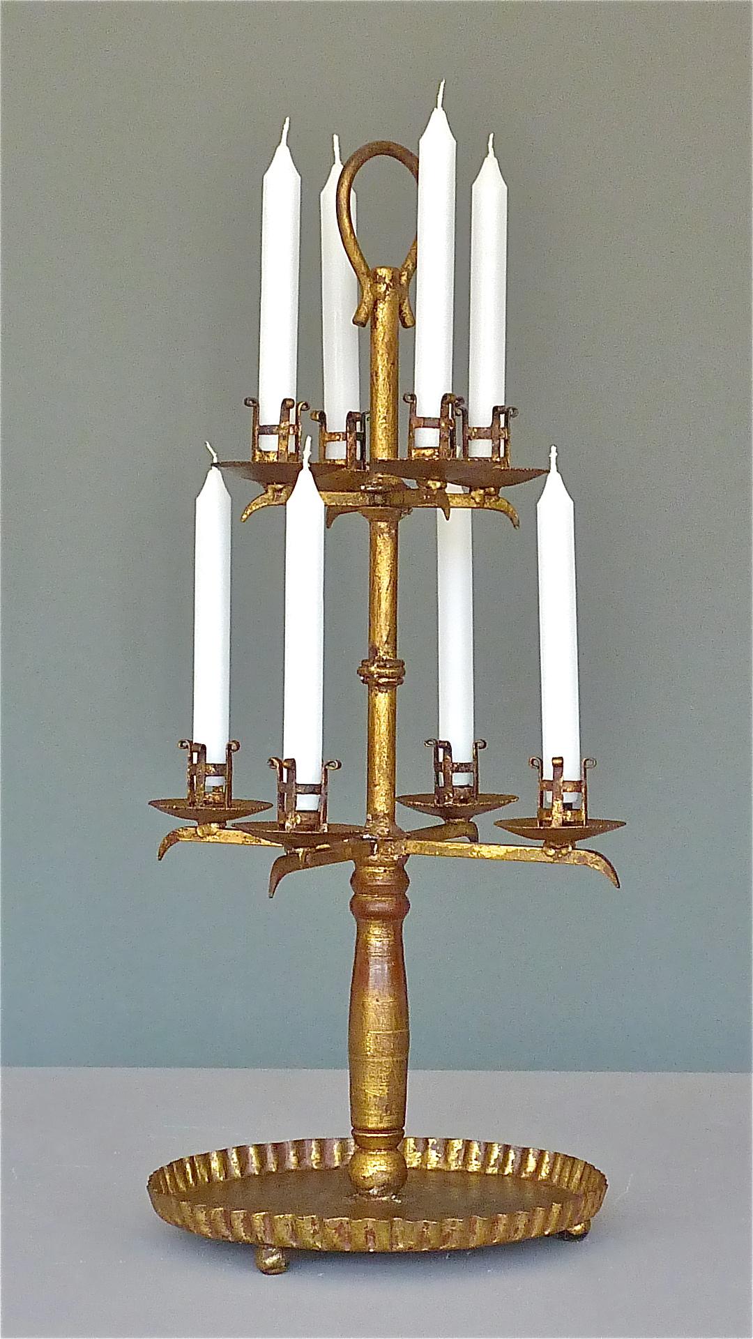 Beautiful and large eight-light Art Deco candleholder or candelabra very in the style of Gilbert Poillerat, France, circa 1930s. The handmade wrought iron candleholder which is gilt on a red ground has a bowl as base which rests on three ball feet.