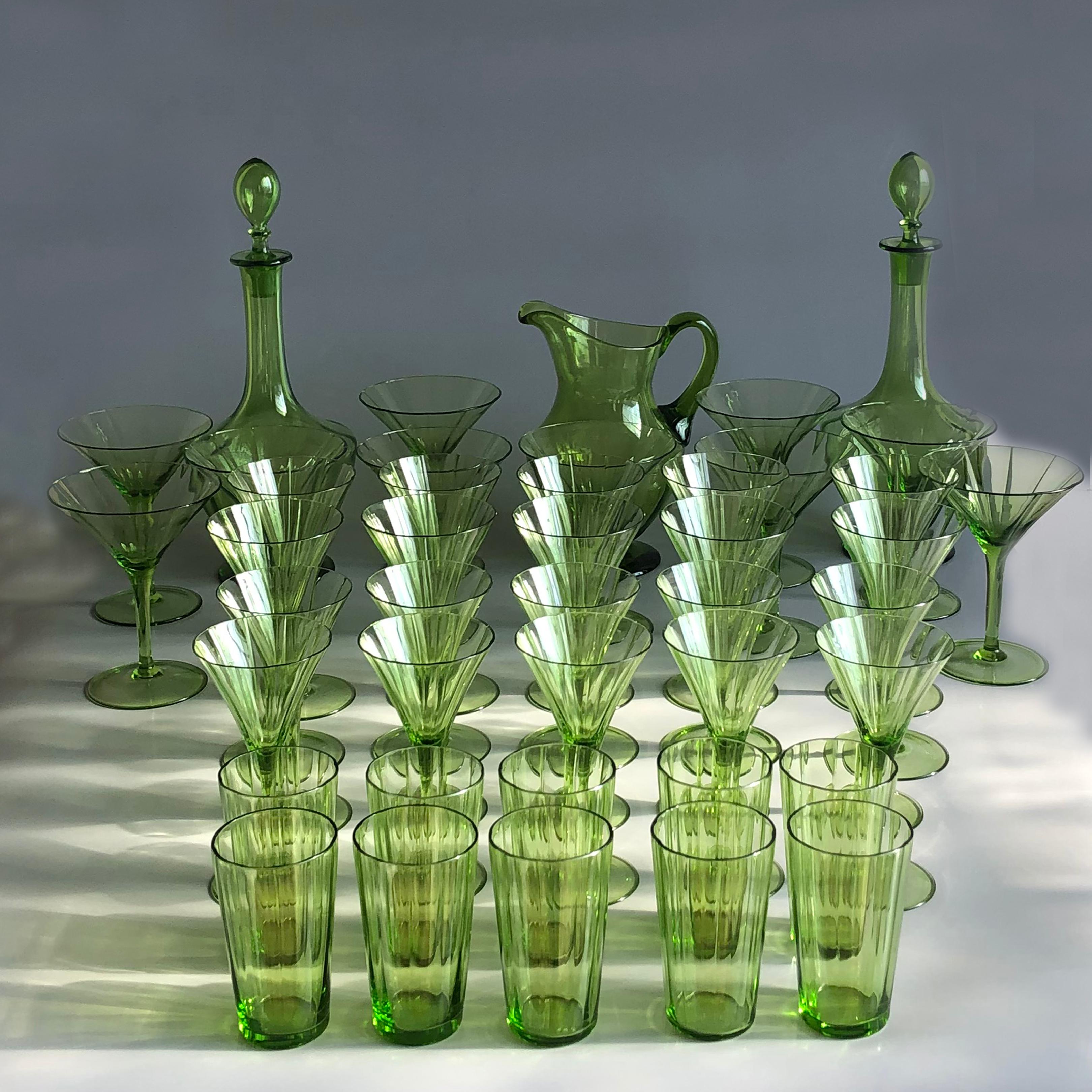 Beautifully handcrafted hand blown green glasses set consisting of 10 champagne, 10 red wine, 10 white wine and 10 water glasses together with one water jug and two carafes with stoppers. No cracks or chips on glasses. The glasses are in outstanding
