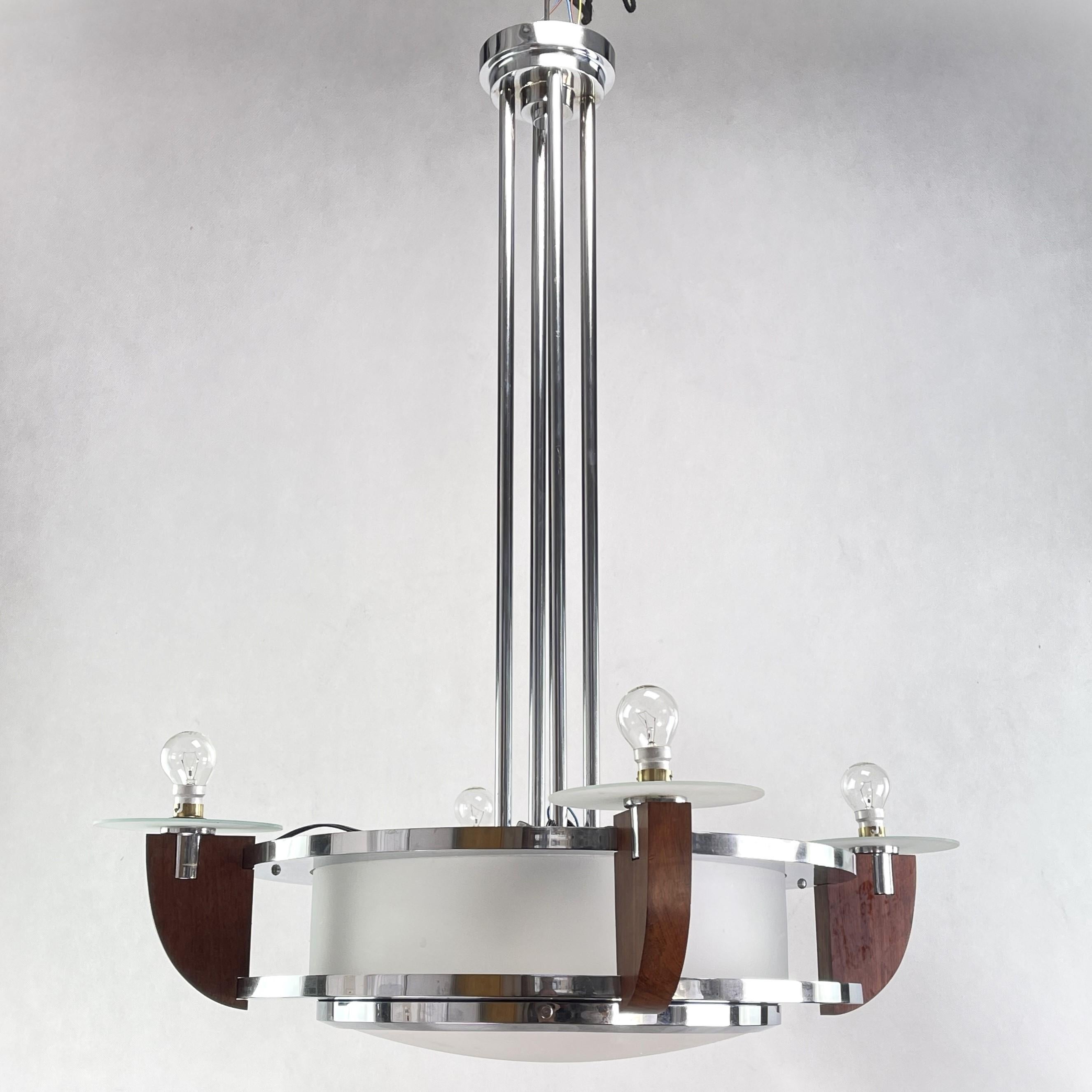 Cette imposante lampe à suspension lourde séduit par son design Art déco simple et sobre. La lampe donne une lumière très agréable. 
Cette lampe impressionnante attire tous les regards. La lampe a toujours ses vieilles lunettes d'origine.

Ce