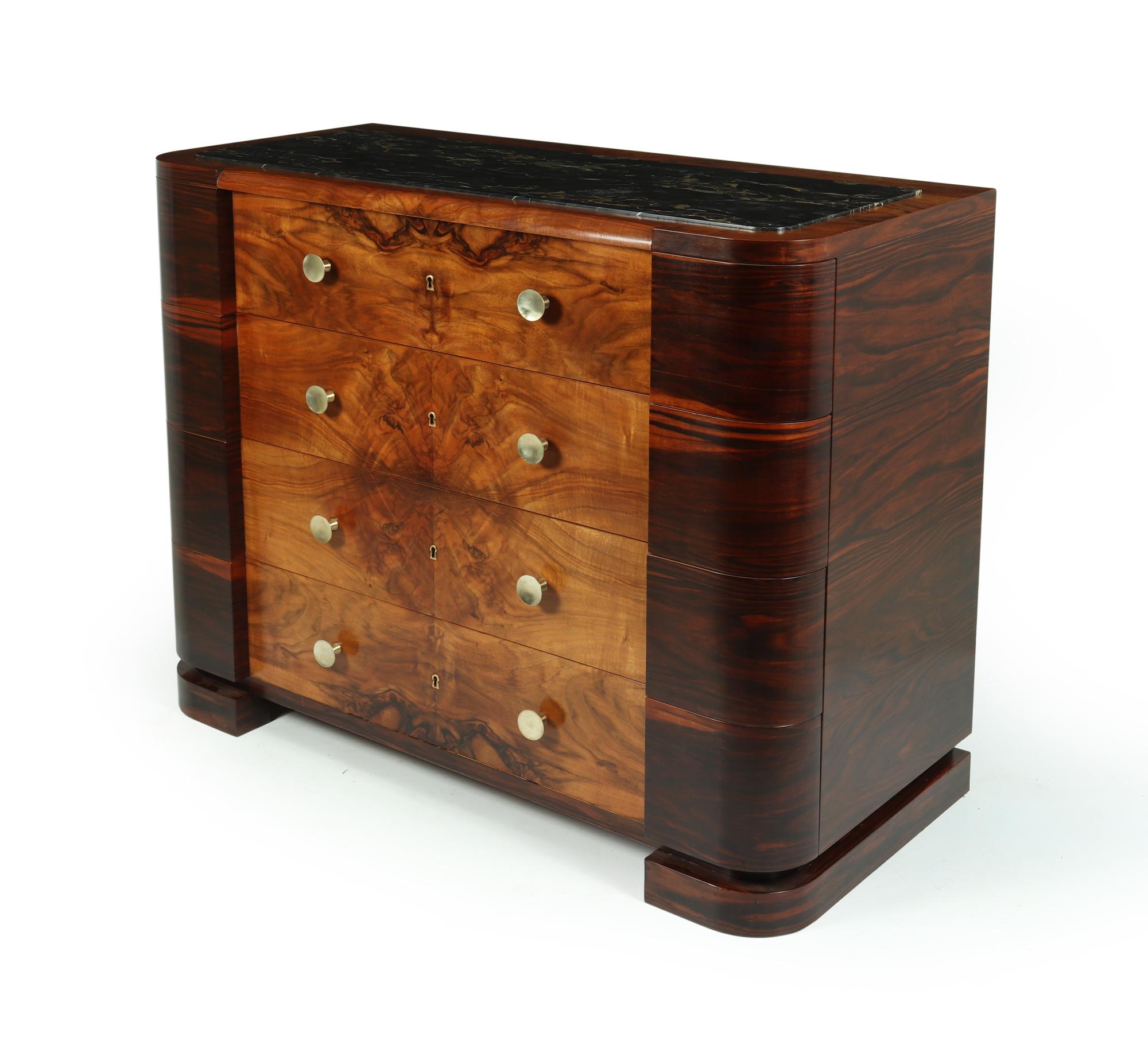 A large chest of drawers produced in Italy in the 1930’s , the chest of drawers is in figured walnut and Macassar ebony and has four long lockable drawers with one original key and inset Portoro marble top

The chest of drawers has been correctly