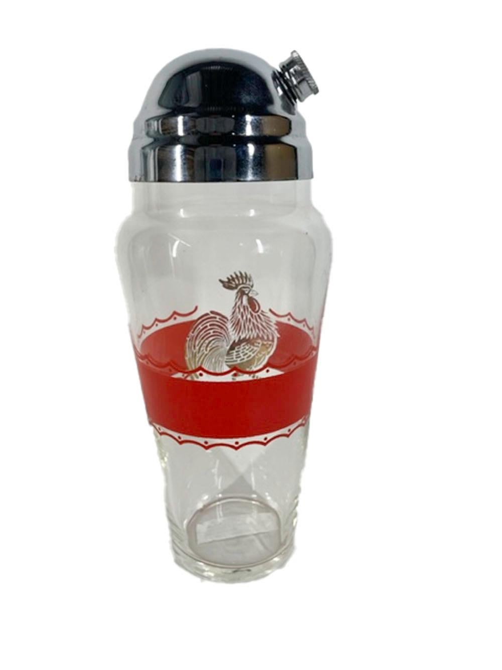 Large art deco glass cocktail shaker with a wide central red enamel bordered with a wavey line and tots above and below and interrupted with a large image of a rooster in 22k gold. The shaker is topped with a high domed chrome lid with a strainer