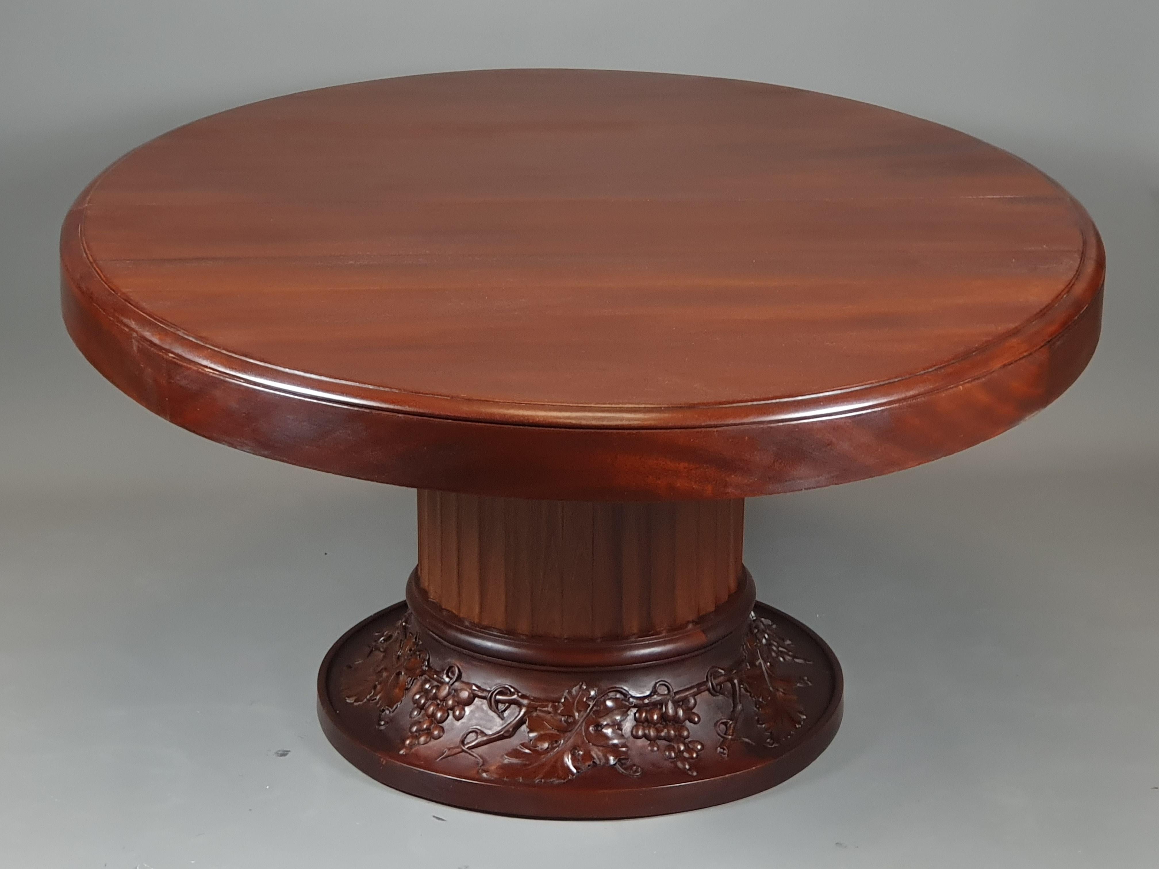 Large table with oval-shaped top and base consisting of an imposing round fluted shaft supported by a flared base carved with vine branches.

Work of quality from Bordeaux around 1930

Top extendable by a so-called French-style slide system