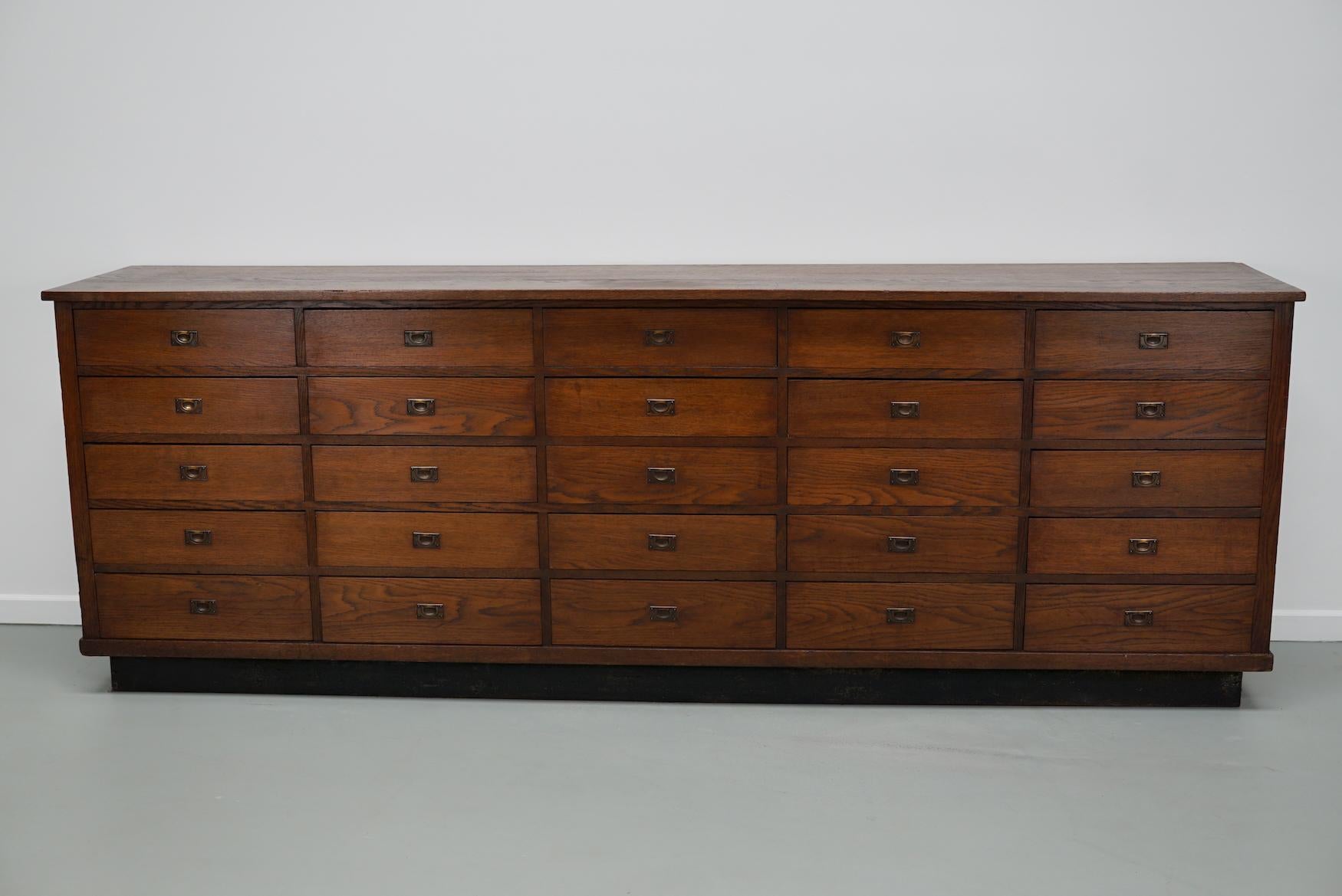 Cette armoire d'apothicaire / de magasin a été produite dans les années 1930 aux Pays-Bas. Il comporte 25 tiroirs avec des ferrures en laiton et reste dans un bon état vintage. Les dimensions intérieures des tiroirs sont les suivantes : DWH 40 x 44
