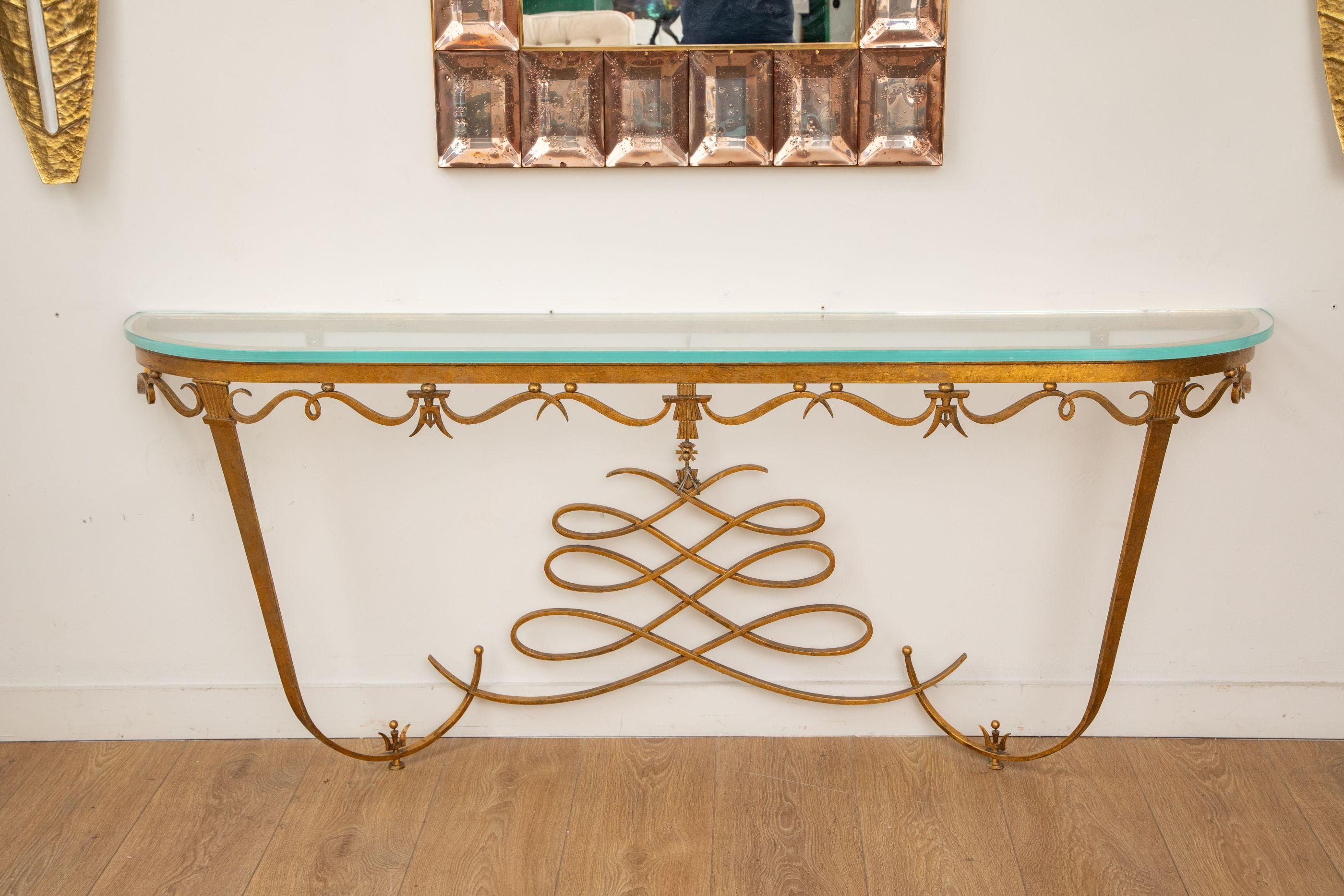 Large Art Deco gilt metal console, France circa 1940
 Striking French wall-mounted console table, circa 1940s, attributed to the refined decorative style of Gilbert Poillerat. This large console features hand-forged gilt ironwork with scroll and