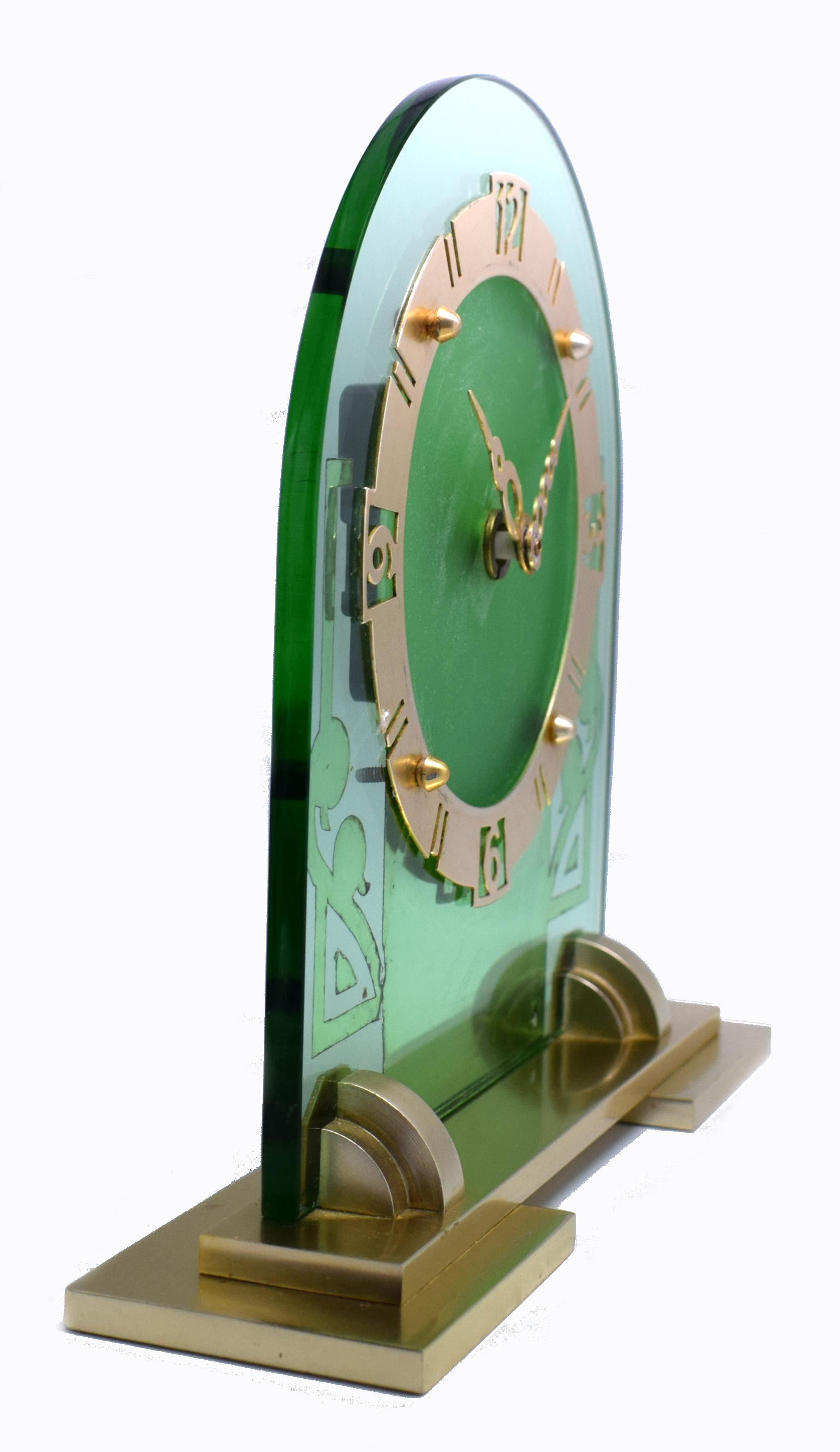 Very attractive and glamorous 1930s Art Deco green mirror clock. Replacement quartz battery movement so no plugs or winding needed. Features a heavy thick green mirror glass face with brass bezel and plinth. The condition is very good with no damage