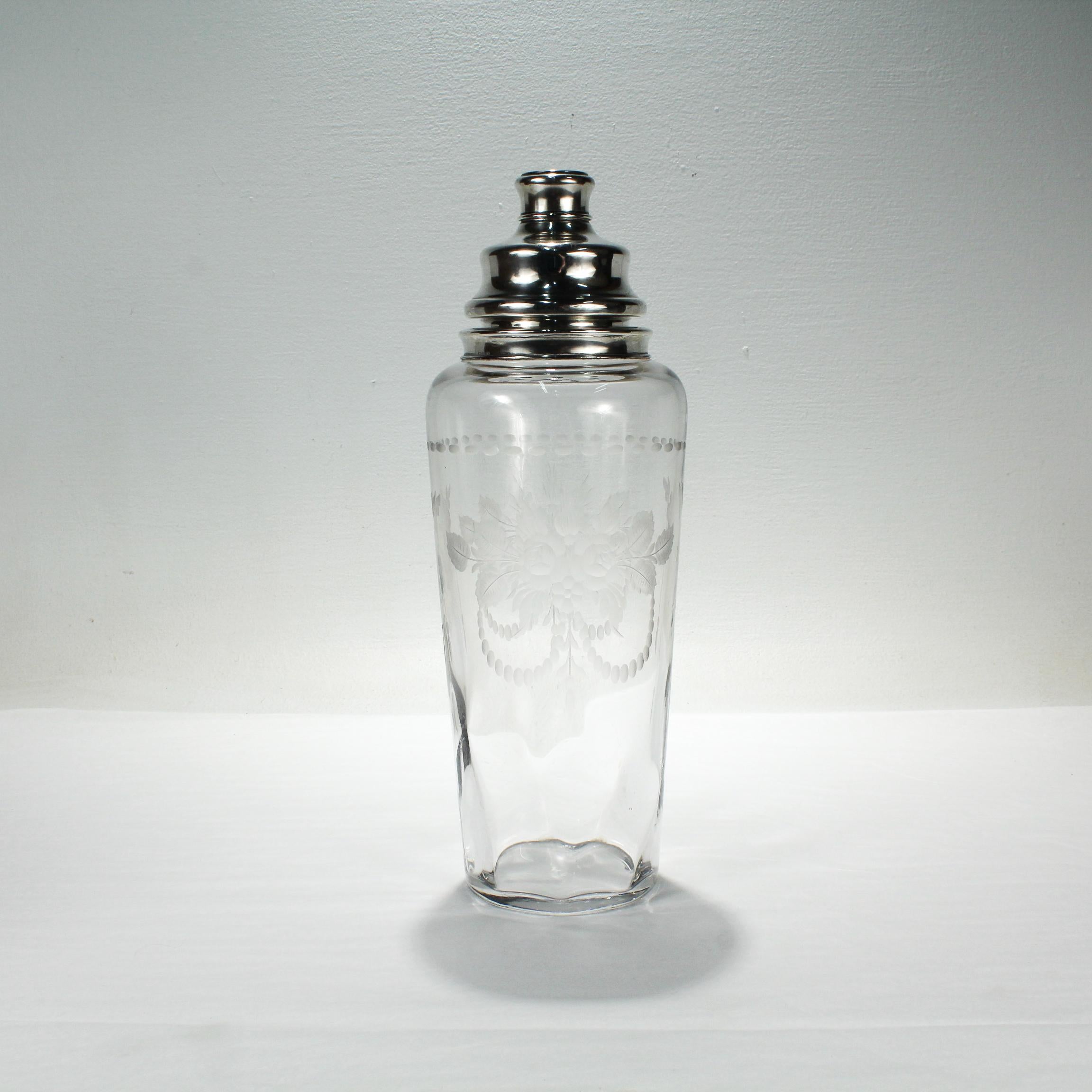 A fine Art Deco sterling silver & engraved glass cocktail shaker.

By Hawkes.

With finely cut, wheel engraved, decoration to the body and a sterling silver mount and lid

Simply a superb cocktail shaker from Hawkes!

Date:
ca. 1930

Overall