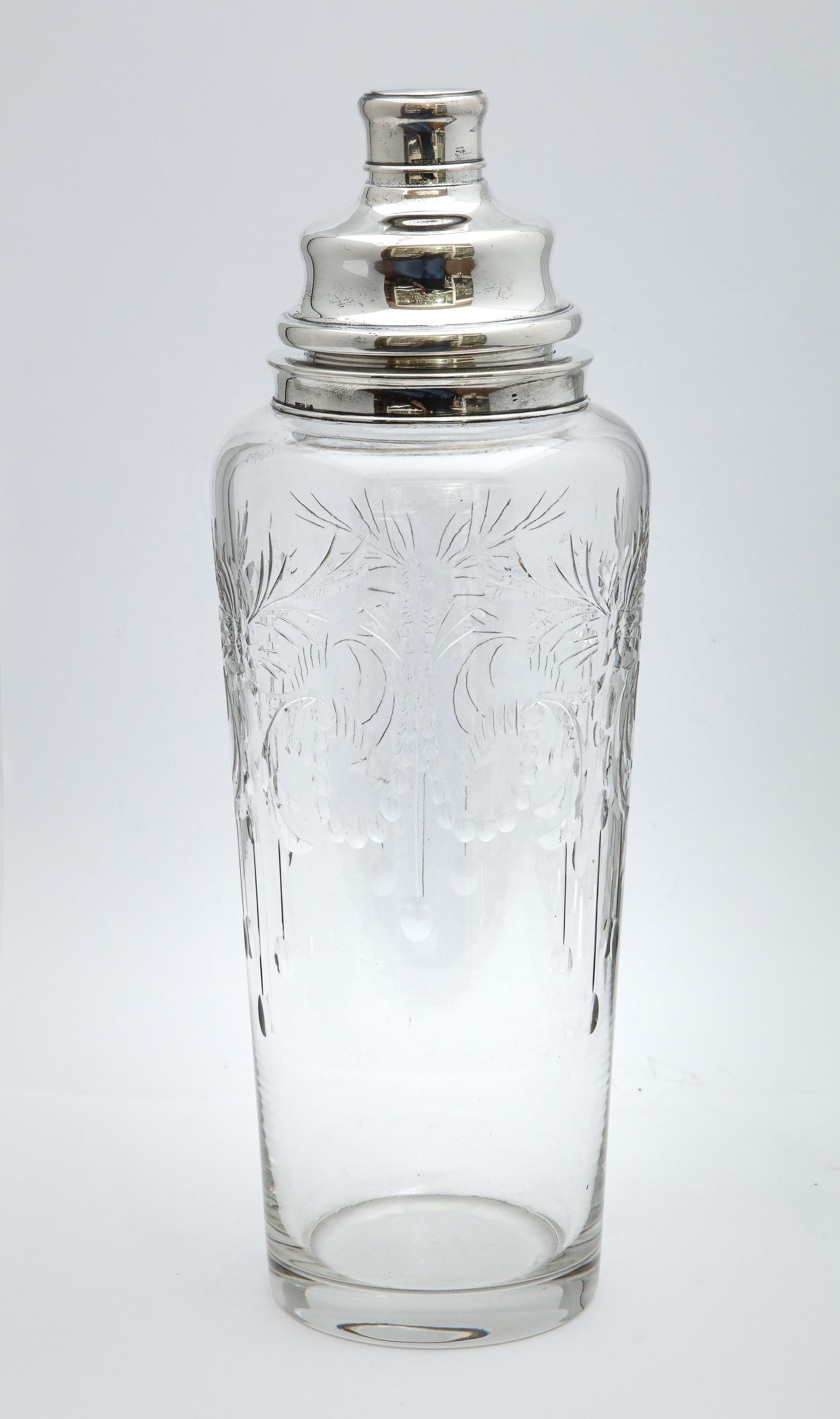 Large, Art Deco, sterling silver-mounted, wheel cut cocktail shaker, T.G. Hawkes and Company, New York, circa 1925. Measures: 13 inches high x 4 1/2 inches diameter at widest point. Beautiful wheel cut glass. Underside of glass shaker is signed with