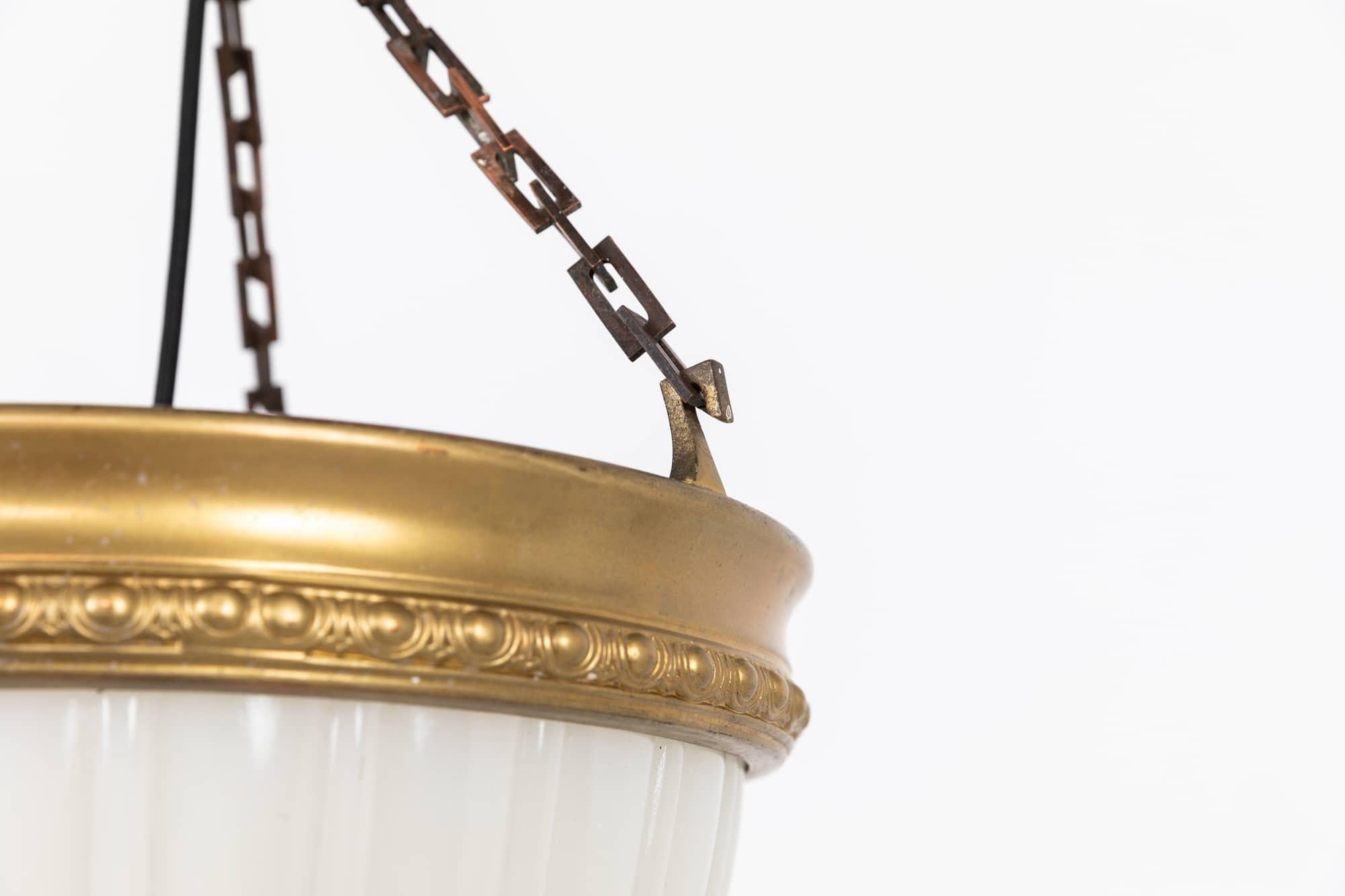 A very elegant pressed glass Jefferson 'Moonstone' plaffonier lamp. c.1930

Heavy duty pressed milk glass of fluted design, supported by pressed gold coloured metal ring, square cut chain, ballhook and matching ceiling hook.

Rewired with black