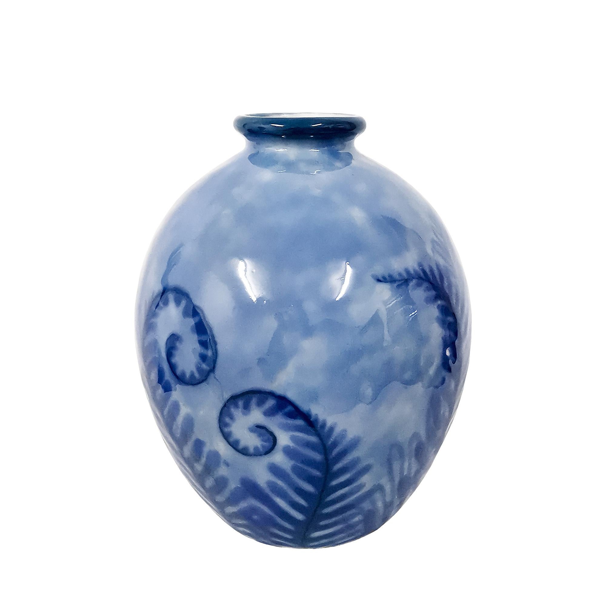 Grand vase en porcelaine de Limoges décoré de fougères dans les tons bleus. Petits défauts de cuisson.

Signé et tamponné : Camille Tharaud.

Limoges, France vers 1930.