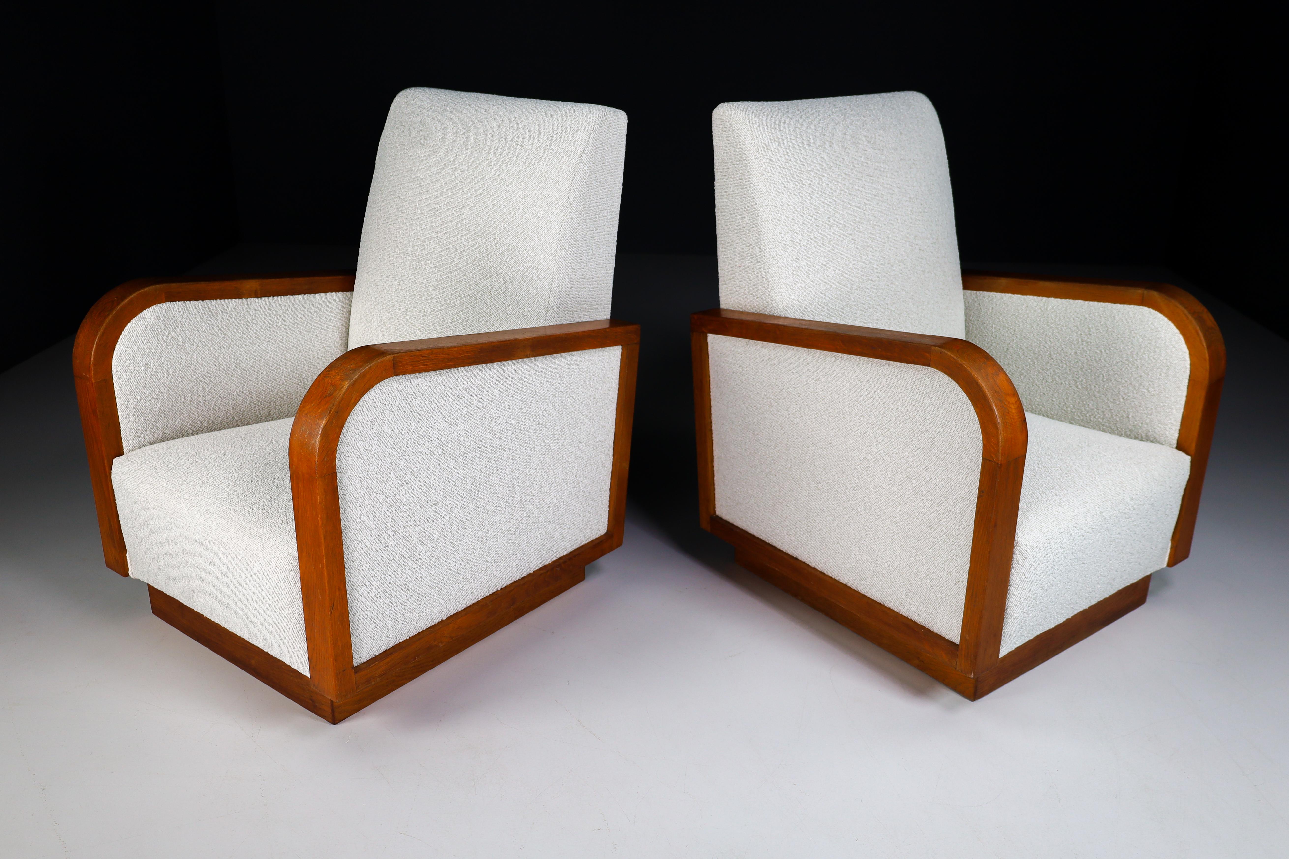 Large size Art Deco lounge chairs manufactured and designed in France 1930s. Made of french oak and these lounge chair has just been reupholstered with Bouclé wool fabric. It is in perfect condition , minor patina on wood parts. These amazing lounge