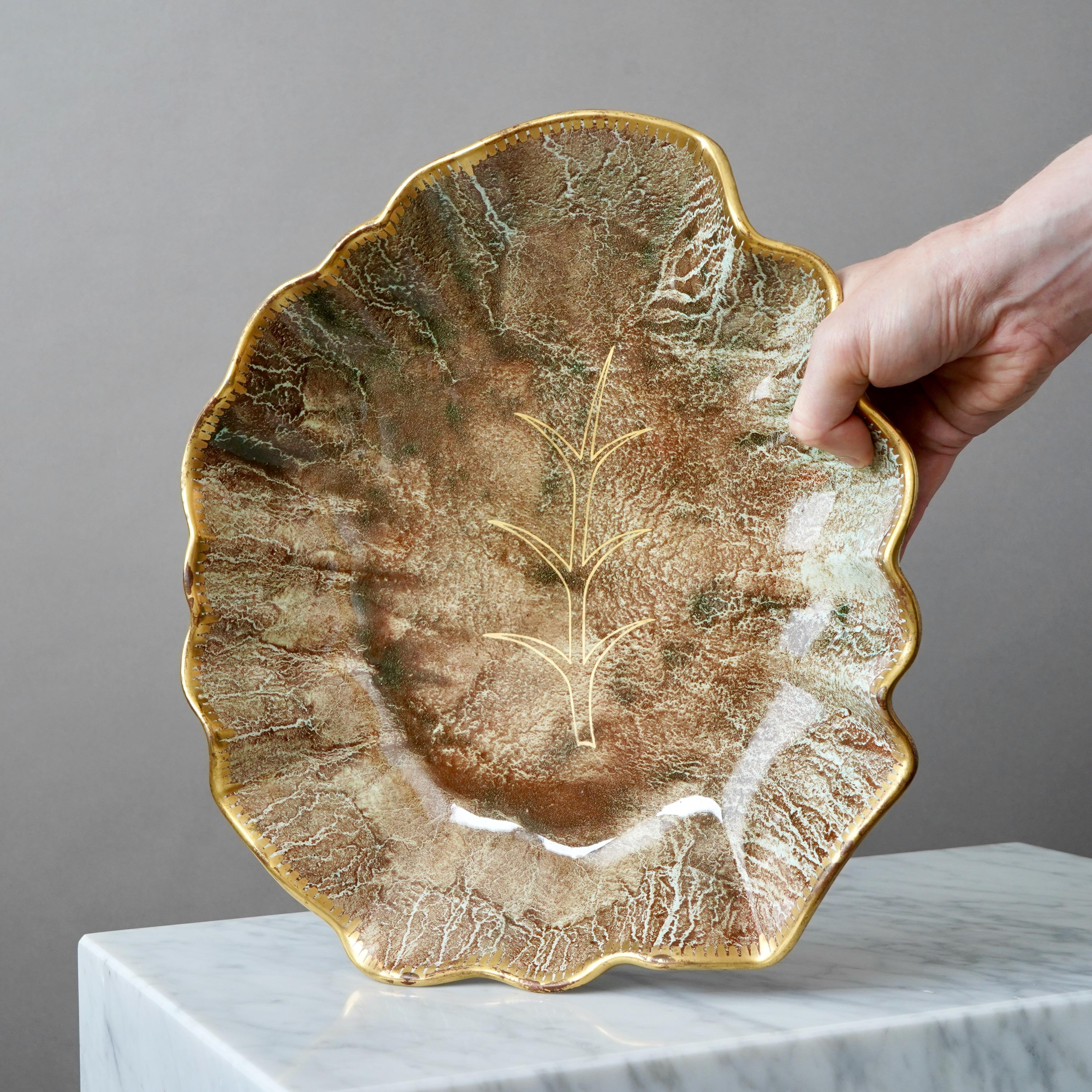 Un piatto grande e raro con un'incredibile smaltatura a lustro e dettagli dorati dipinti a mano. Grazia scandinava / Art Deco.
Realizzata da Josef Ekberg a Gustavsberg, Svezia, negli anni '1930.

Ottime condizioni. L'oro è un po' scolorito in alcune
