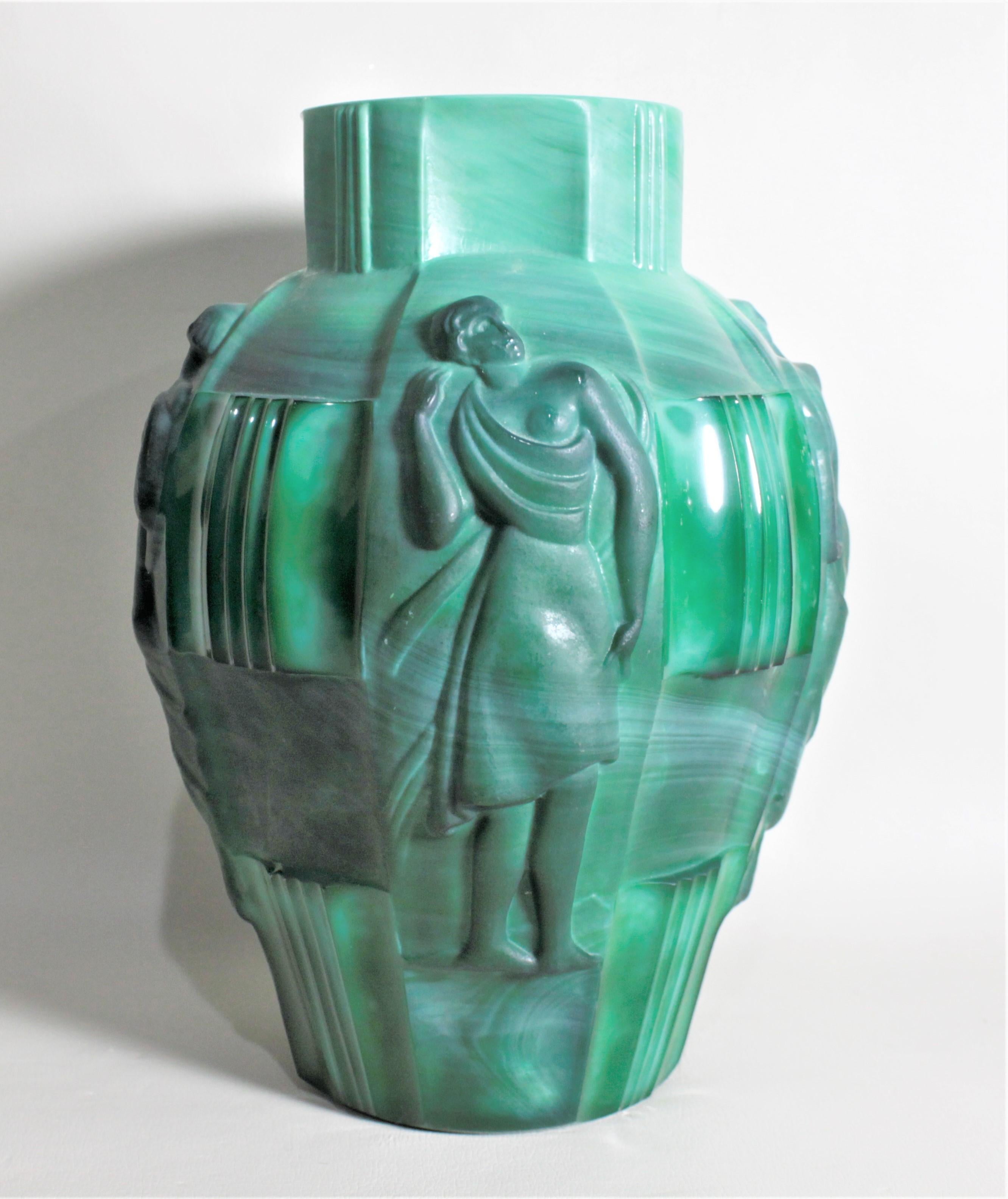 This large jade green malachite vase was presumably done in the now Czech Republic in circa 1930 in the period Art Deco style. The vase has four detailed panels of neoclassical figures on the sides which are separated by panels of simple linear