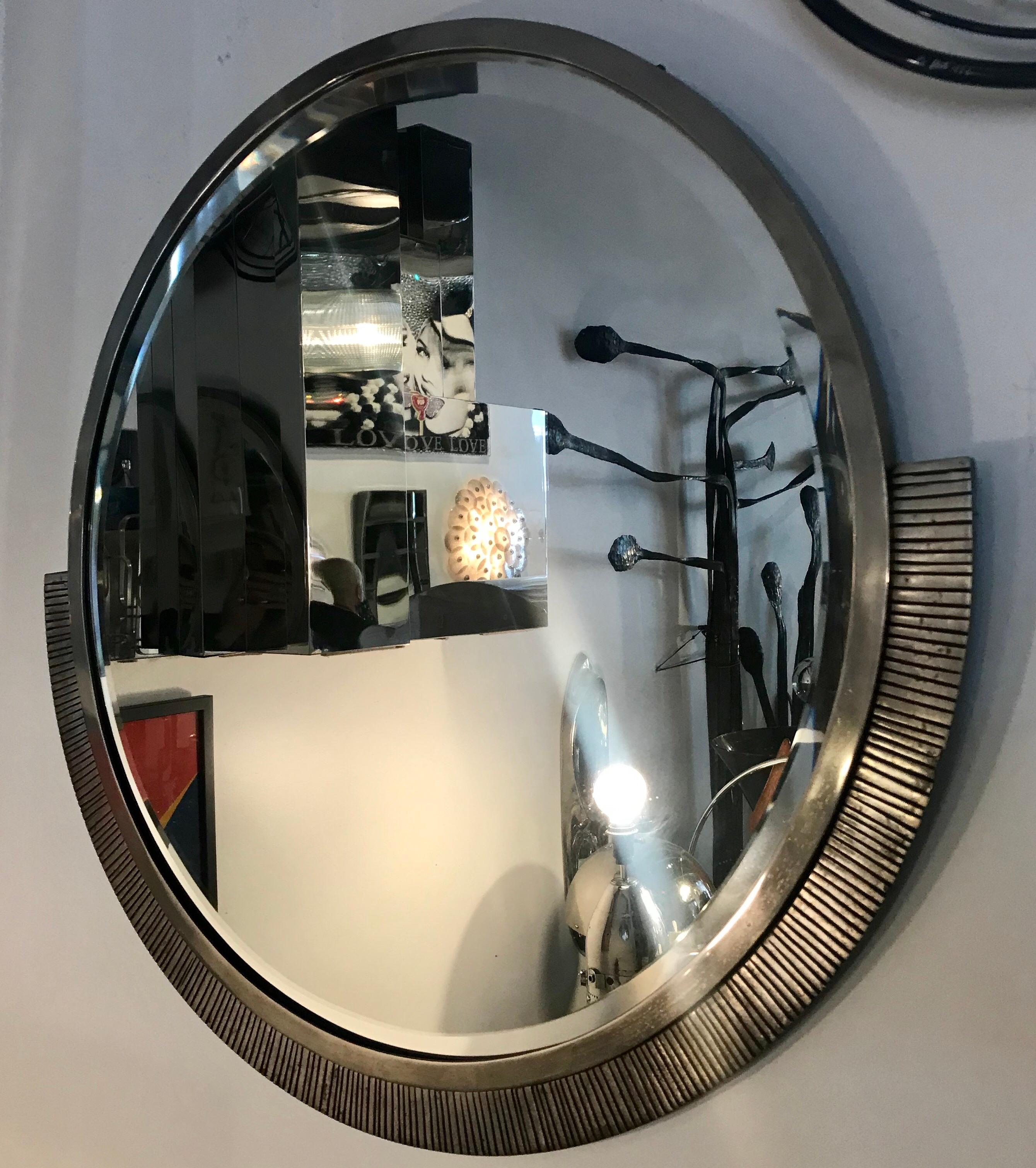 Large round mirror by Edgar Brandt (1880-1960) in nickel-plated wrought iron and bronze frame.
The frame is asymmetric in a typical modernist style, circa 1930. Stamped on the frame, E.Brandt.
 