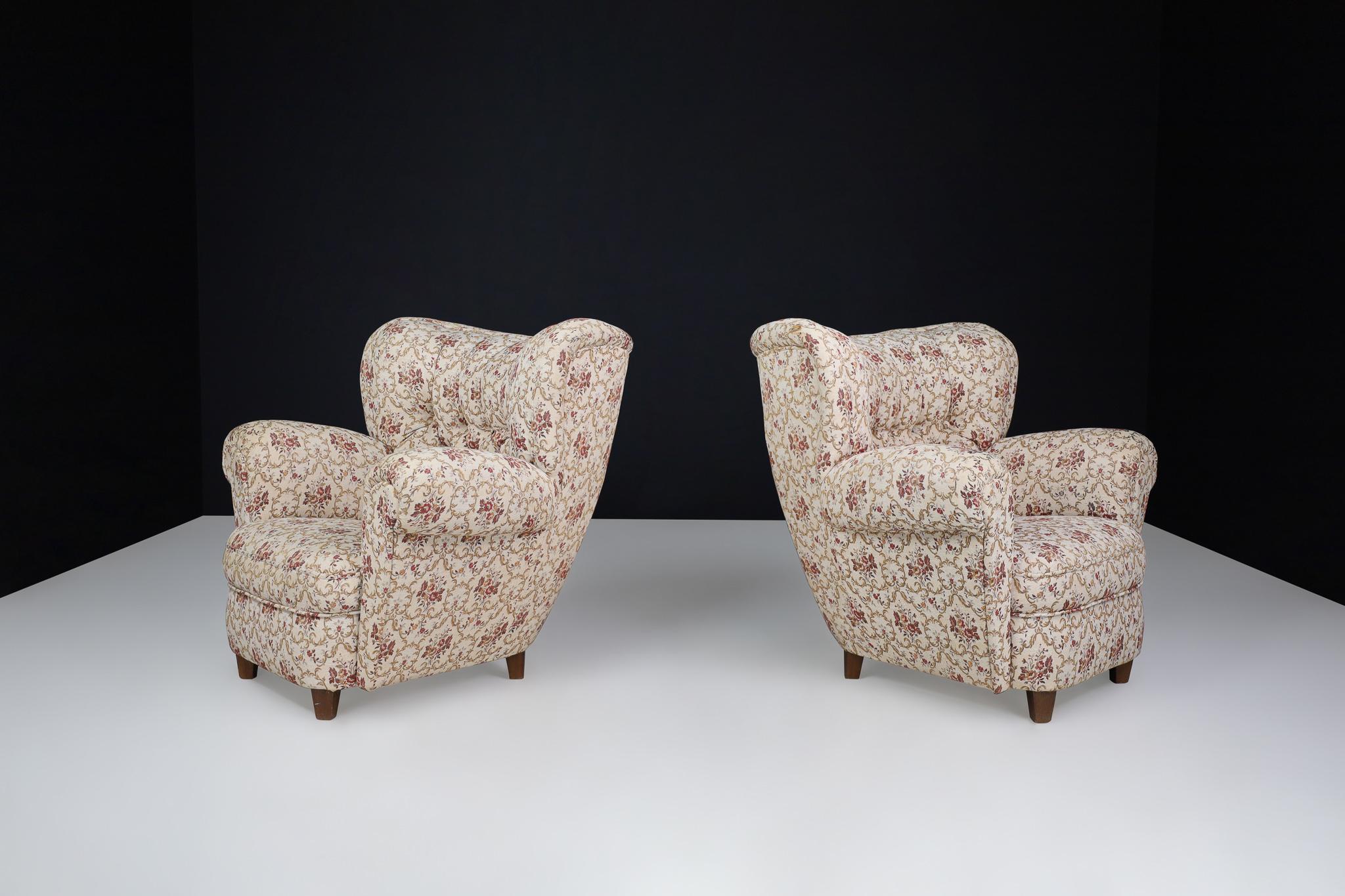 Large Art-Deco Pair Armchairs in Original Floral Upholstery, Praque 1930

These large Art Deco armchairs were crafted in Prague during the 1930s and still feature their original floral upholstery. Their soft edges, tufted lines, and sturdy design