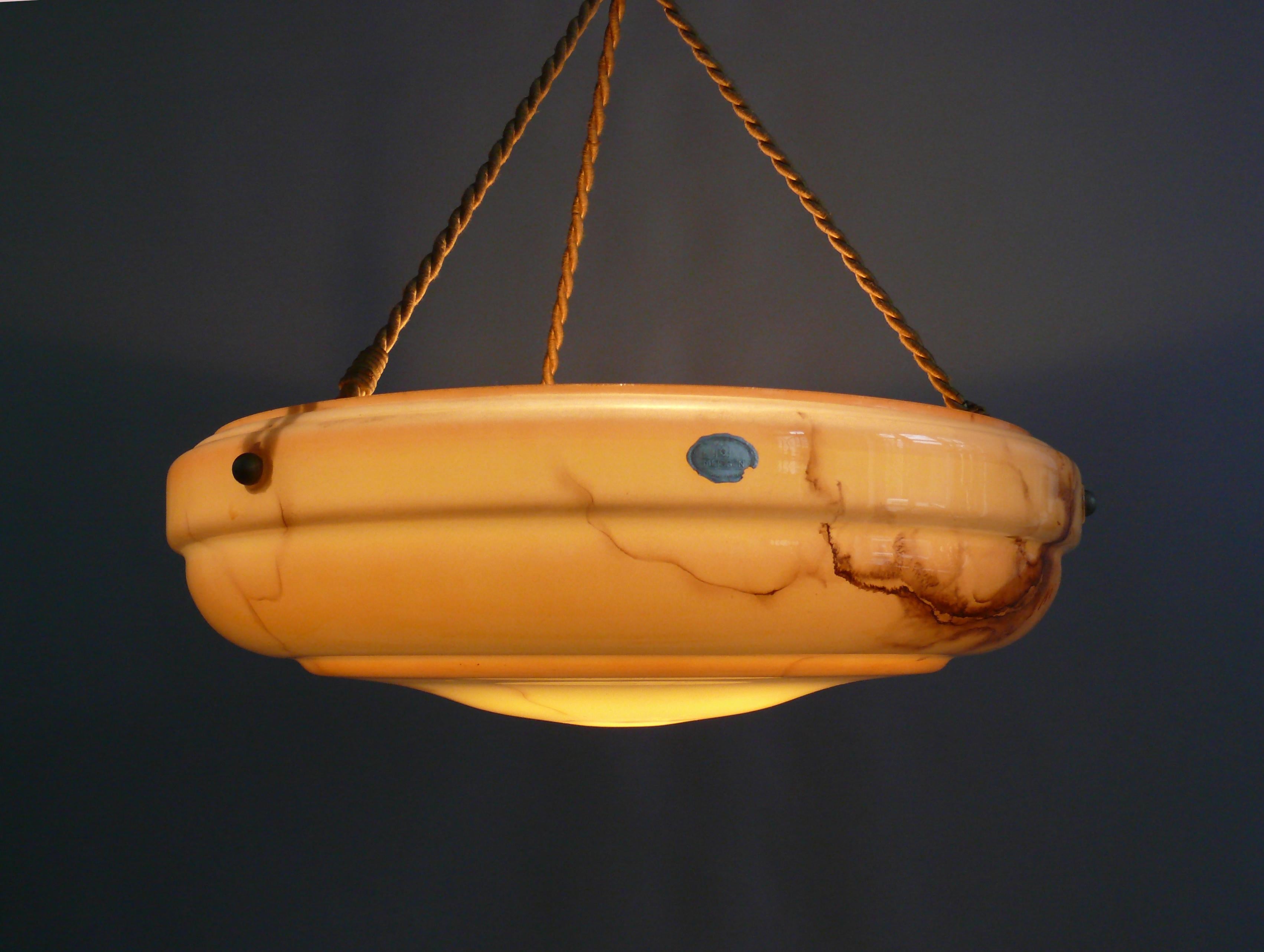 Large pendant lamp from the 1920s-1940s with a marbled glass shade and cable suspension in good original condition. The glass shade bears a company label with the inscription 