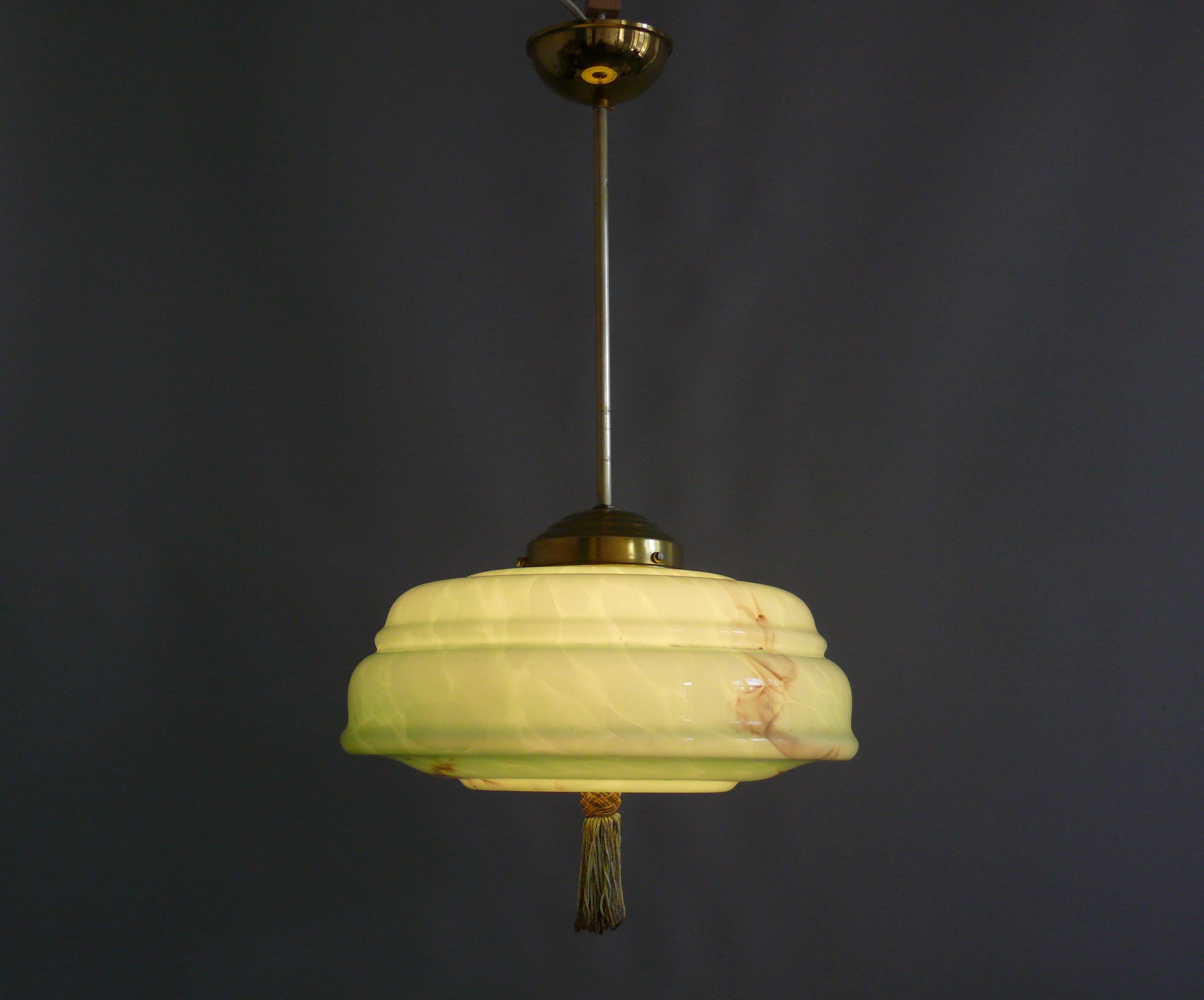 Large Art Deco rod pendant lamp from the 1930s - 1940s with a very beautiful profiled, mint green glass shade and tassel. The glass shade is marbled and is in very good condition. The suspension is made of brass and was stylishly renewed from