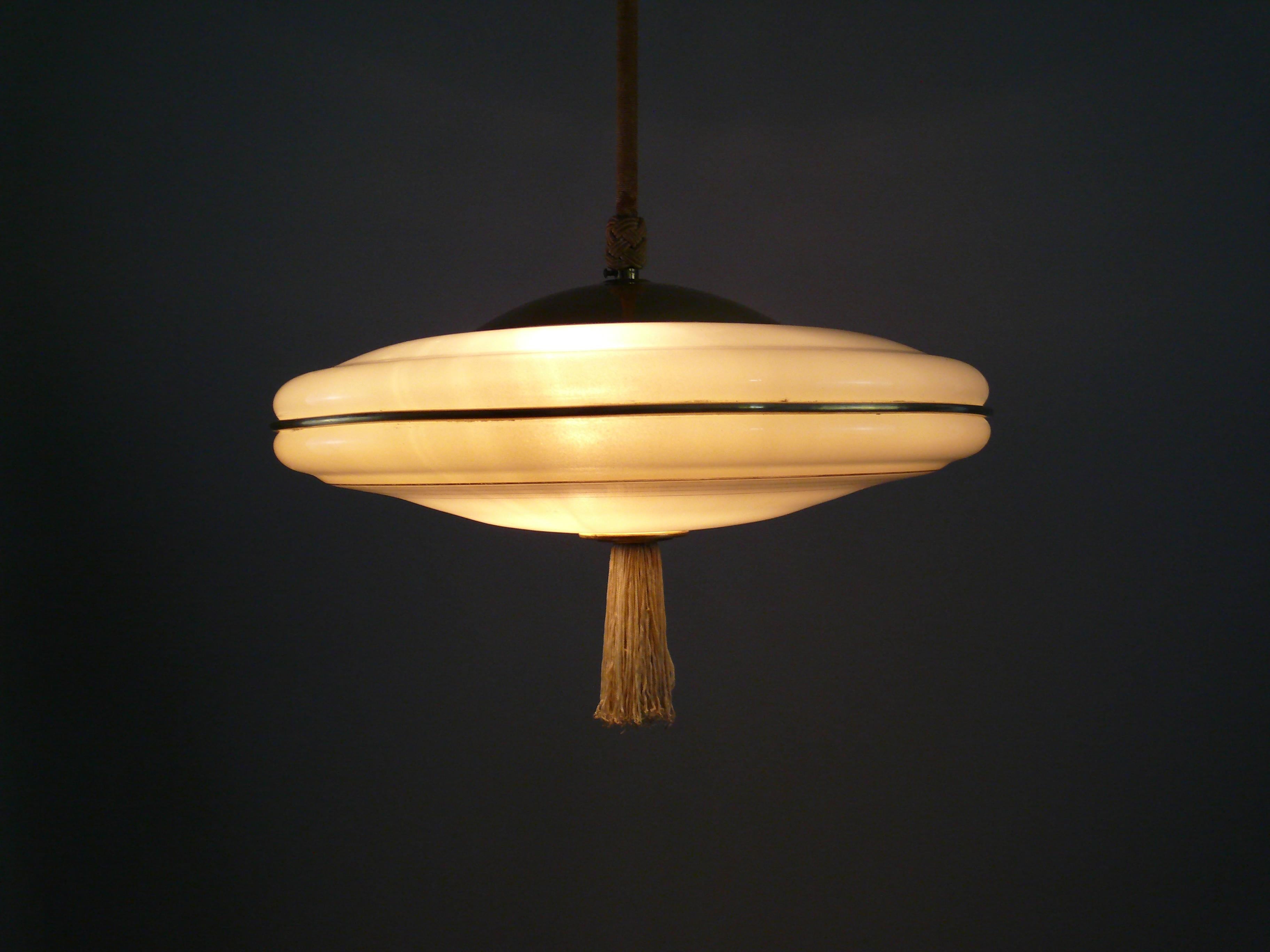 Rare Art Deco rod pendant lamp with decorated, ivory-colored glass shade from the 1930s. The glass shade is in very good condition, as are the radial gold stripes. On the outer edge there is even a real brass profile that is inserted into the glass