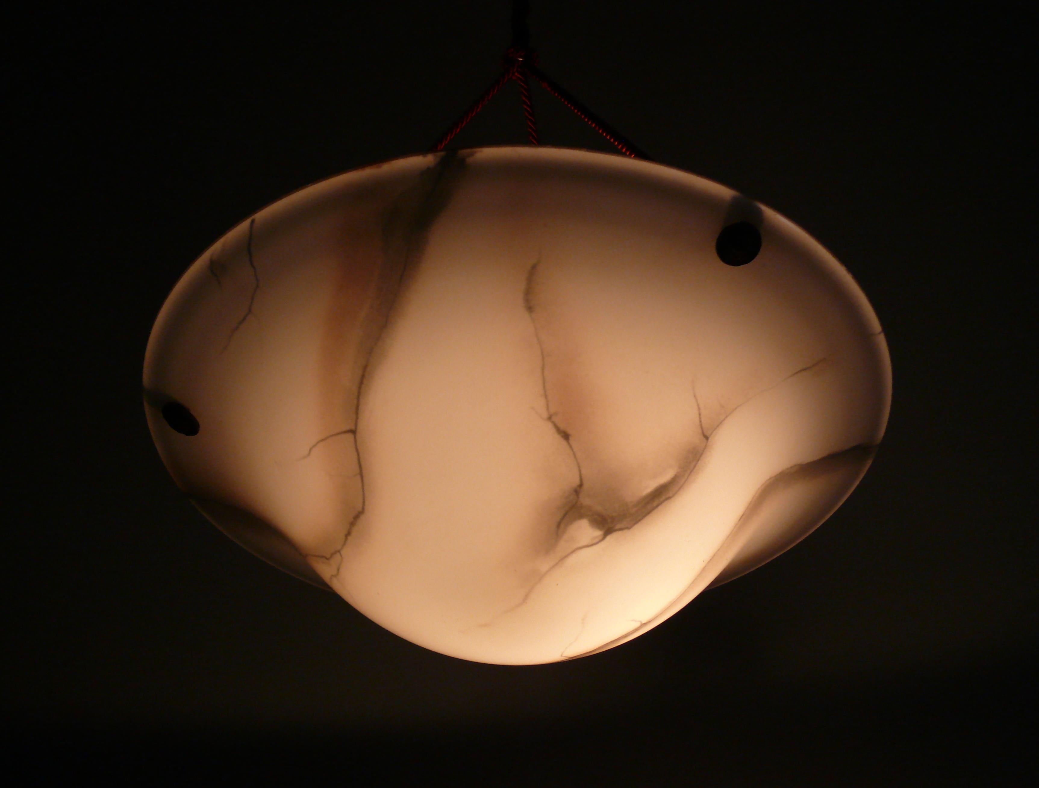 Lampada a sospensione Art Deco degli anni '40 - '60 con paralume in vetro marmorizzato e sospensione in corda in buone condizioni. Il grande paralume in vetro bianco ha una bellissima forma a conchiglia con sfumature marroni e un colore che ricorda
