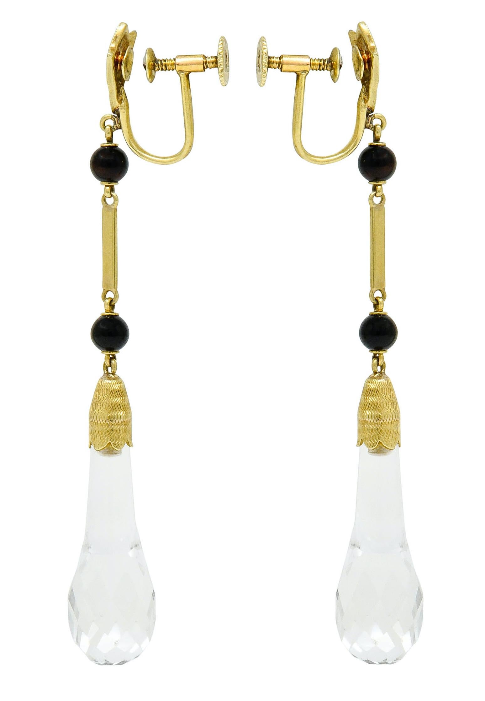 Drop earrings with a milgrain foliate surmount suspending two 4.1 mm onyx beads that center a polished gold bar

Terminating as a rock crystal drop with a faceted briolette base and scalloped gold cap featuring a deeply ridged texture

Completed by