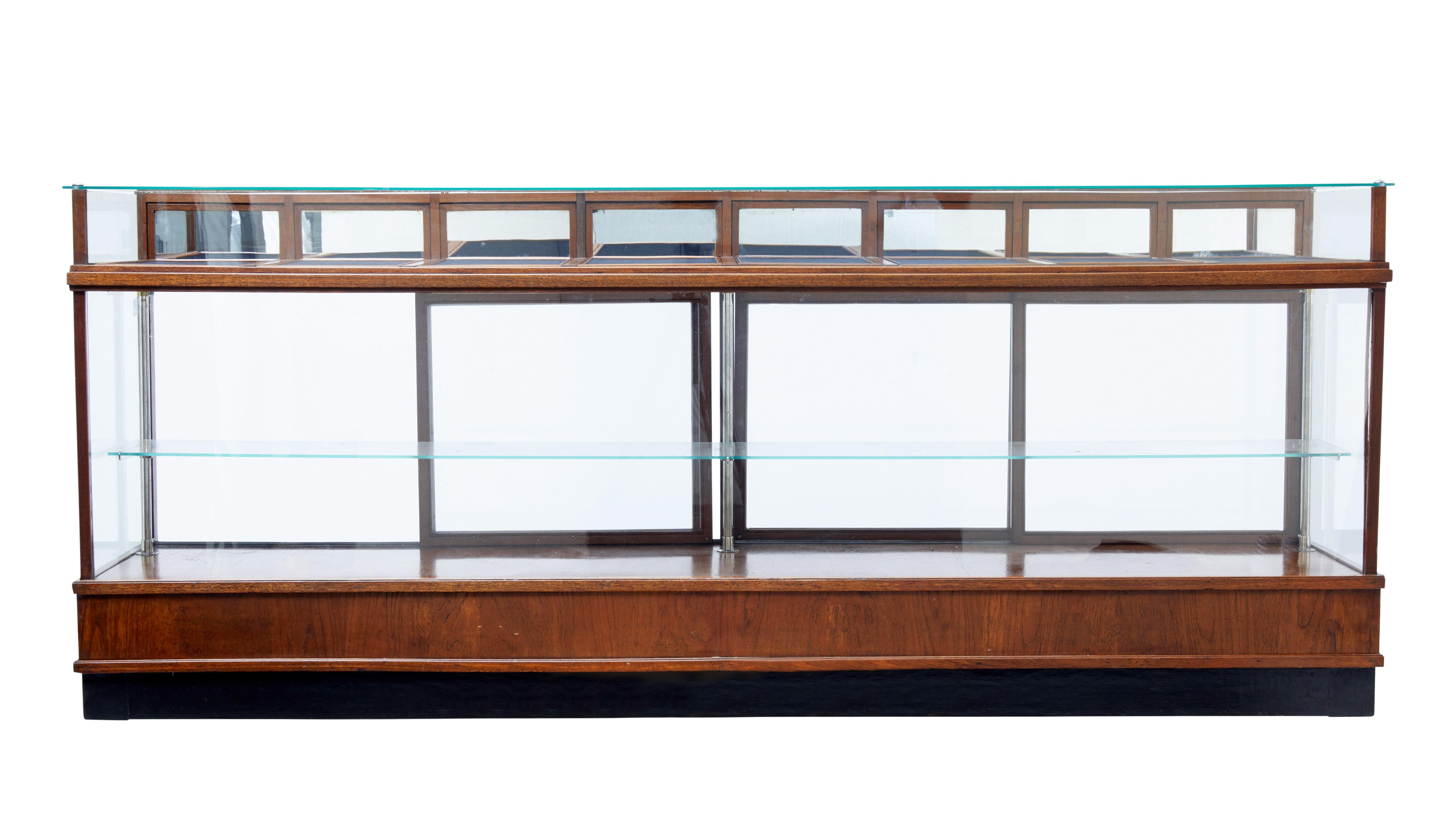 Large impressive haberdashery shop display, circa 1930.

Glazed front, sides and top. Presented in a teak frame standing on a ebonised plinth.

Single glazed shelf held in place by three chrome supports, the shelf is accessible by four-sliding